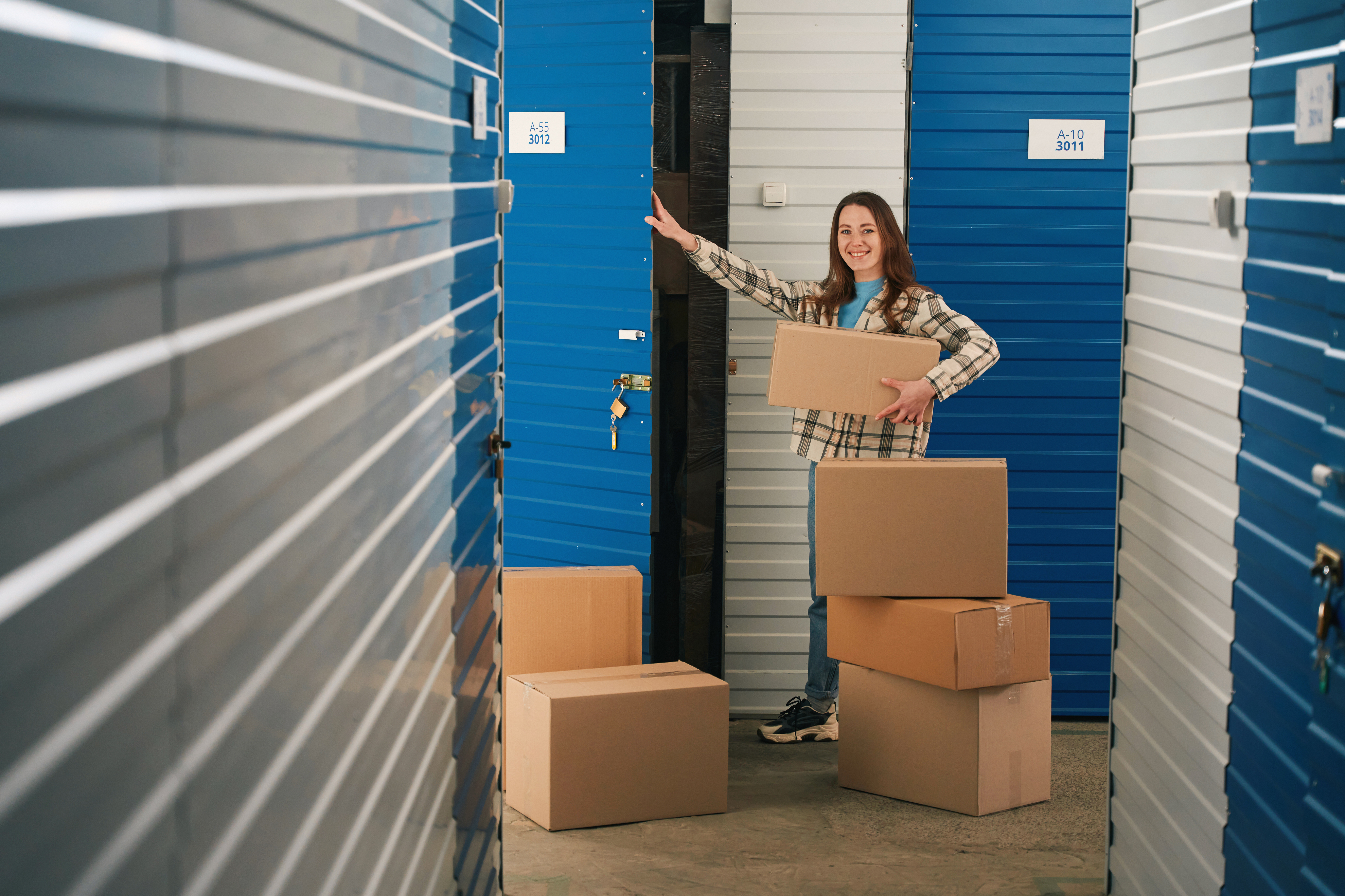 Woman moving boxes into a storage unit while comparing storage unit costs in Reno, NV.