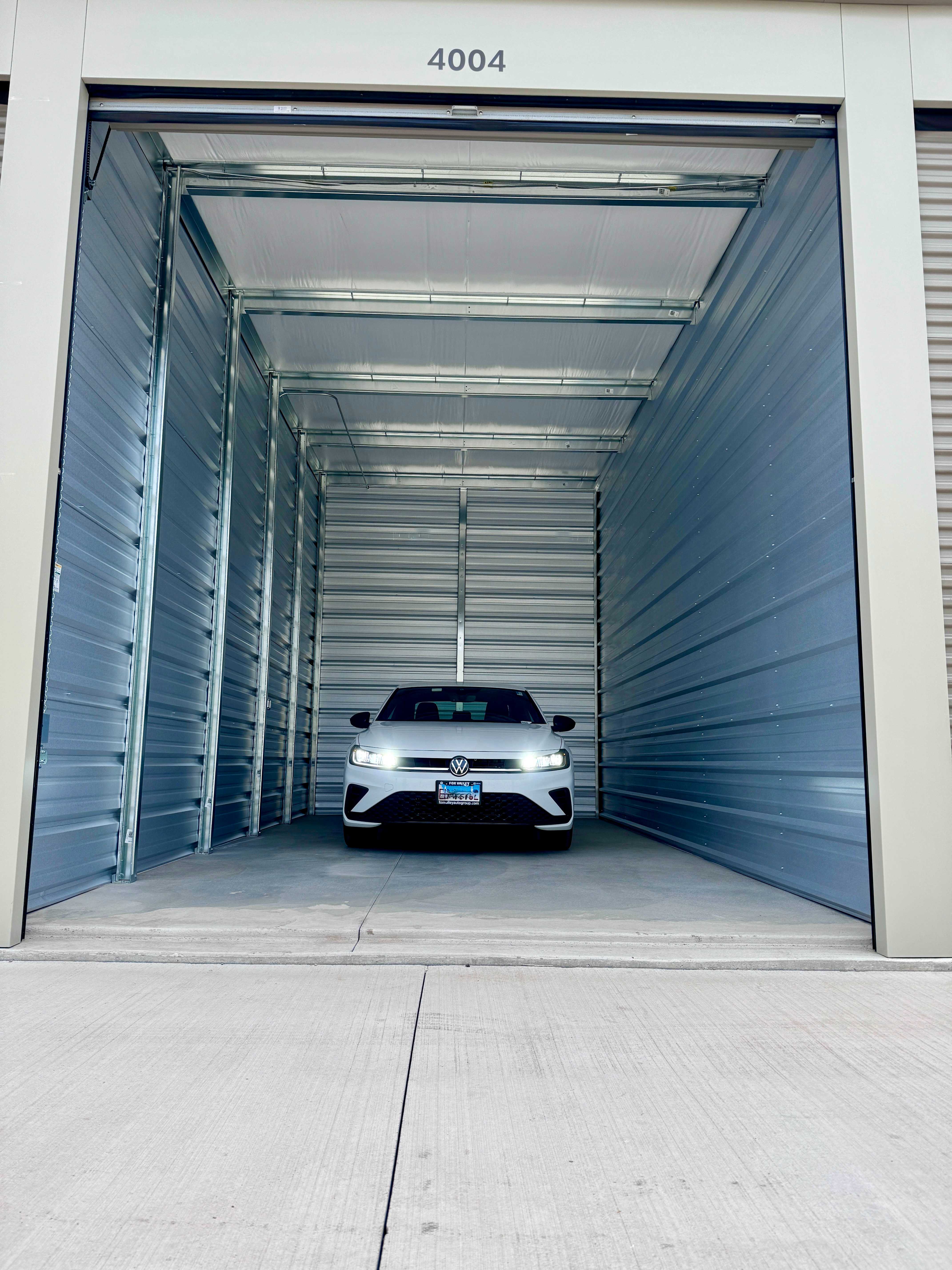 Drive-up storage unit 4004 with a vehicle parked inside at Storage Junction in Genoa City, WI