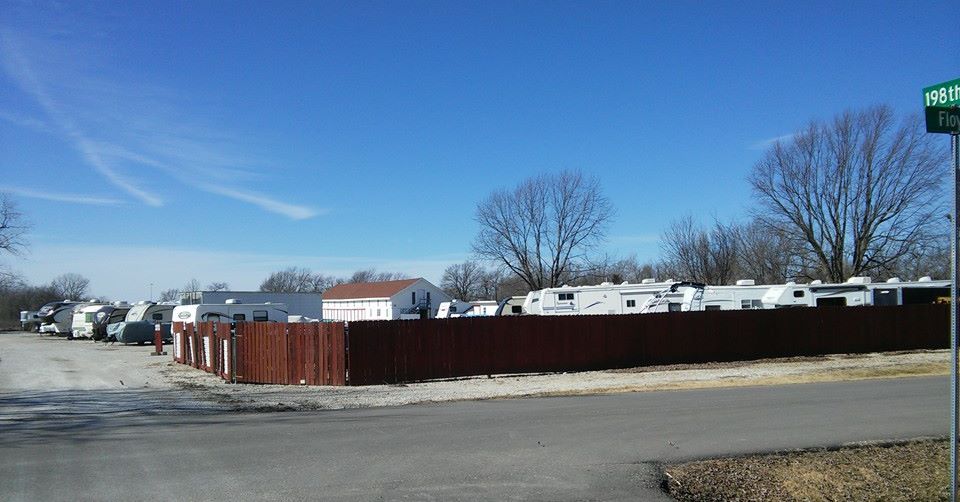 fenced parking facility with RVs and boats