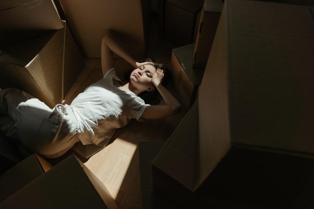 A woman lying down surrounded with boxes