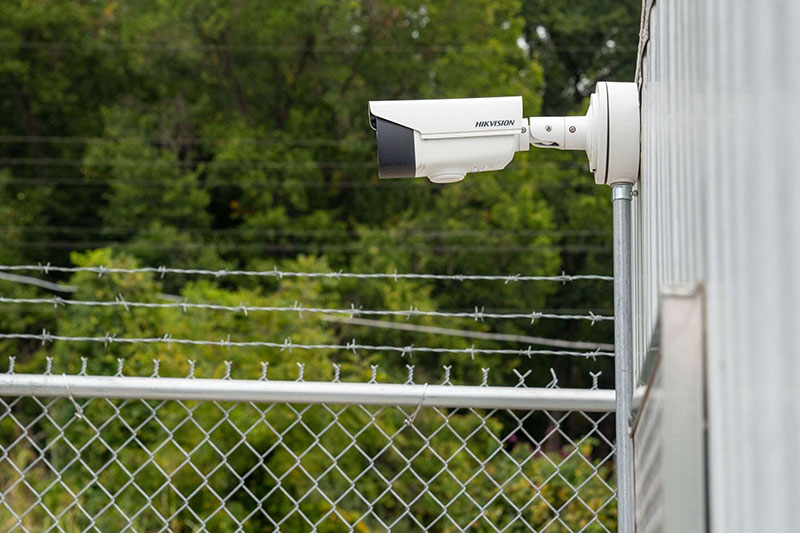 security-camera-installed-next-to-secure-fence-with-barbed-wire.jpg
