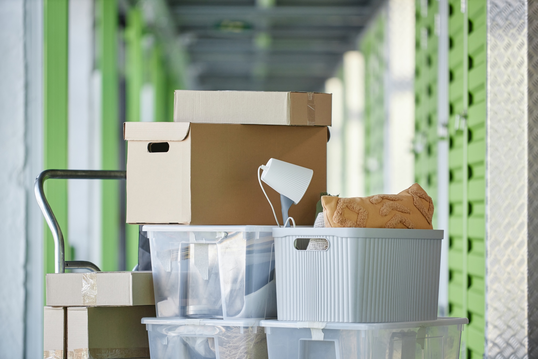 Boxes and plastic totes on a rolling moving cart.