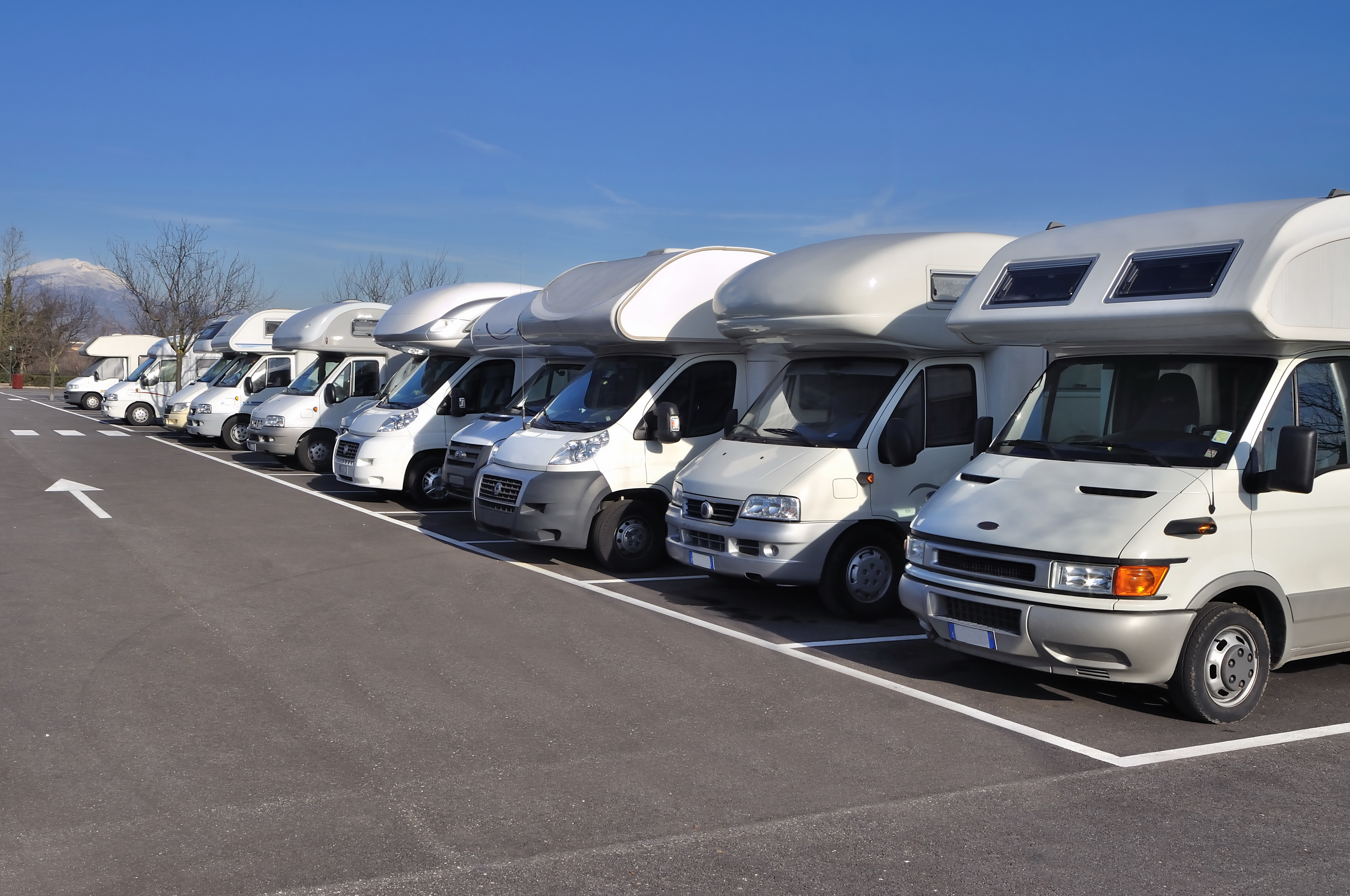 A row of recreational vehicles in parking spaces