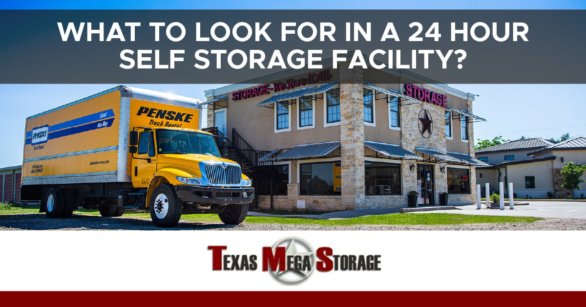 A yellow Penske moving truck parked in front of a large brick storage building. A banner reads “What to look for in a 24 hour self storage facility?”