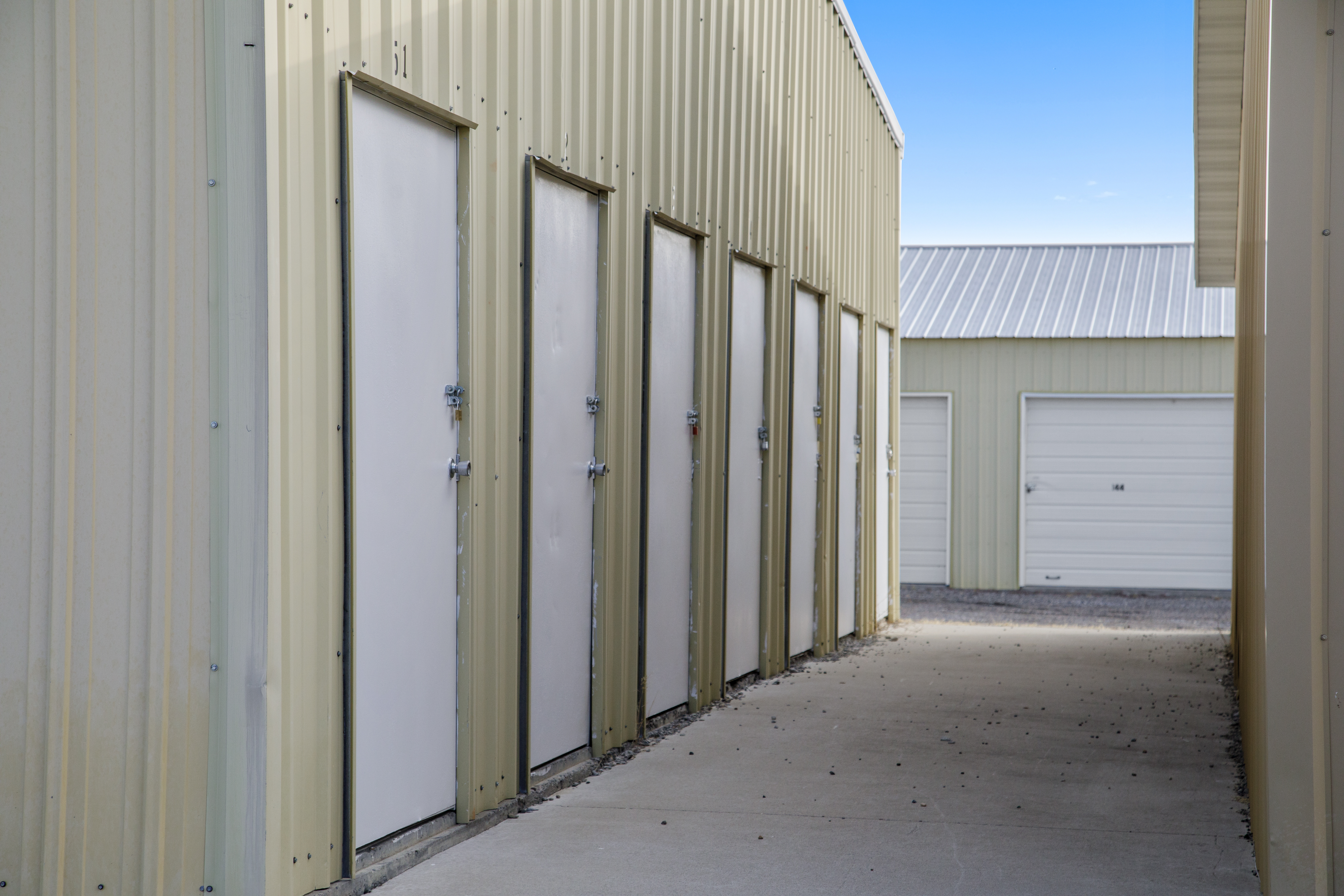 tan building with white doors to storage units