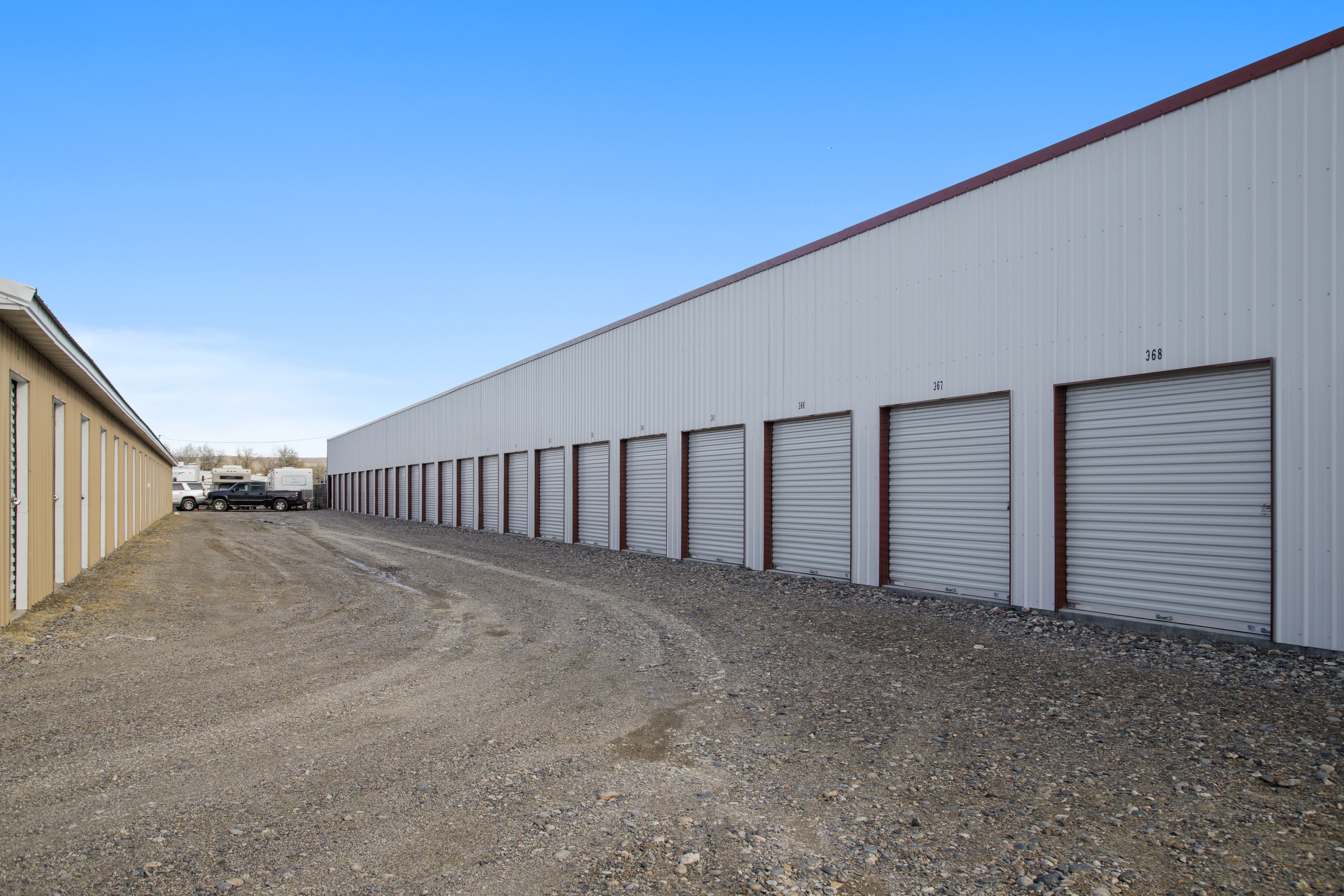 white building with white drive up accessible storage unit doors