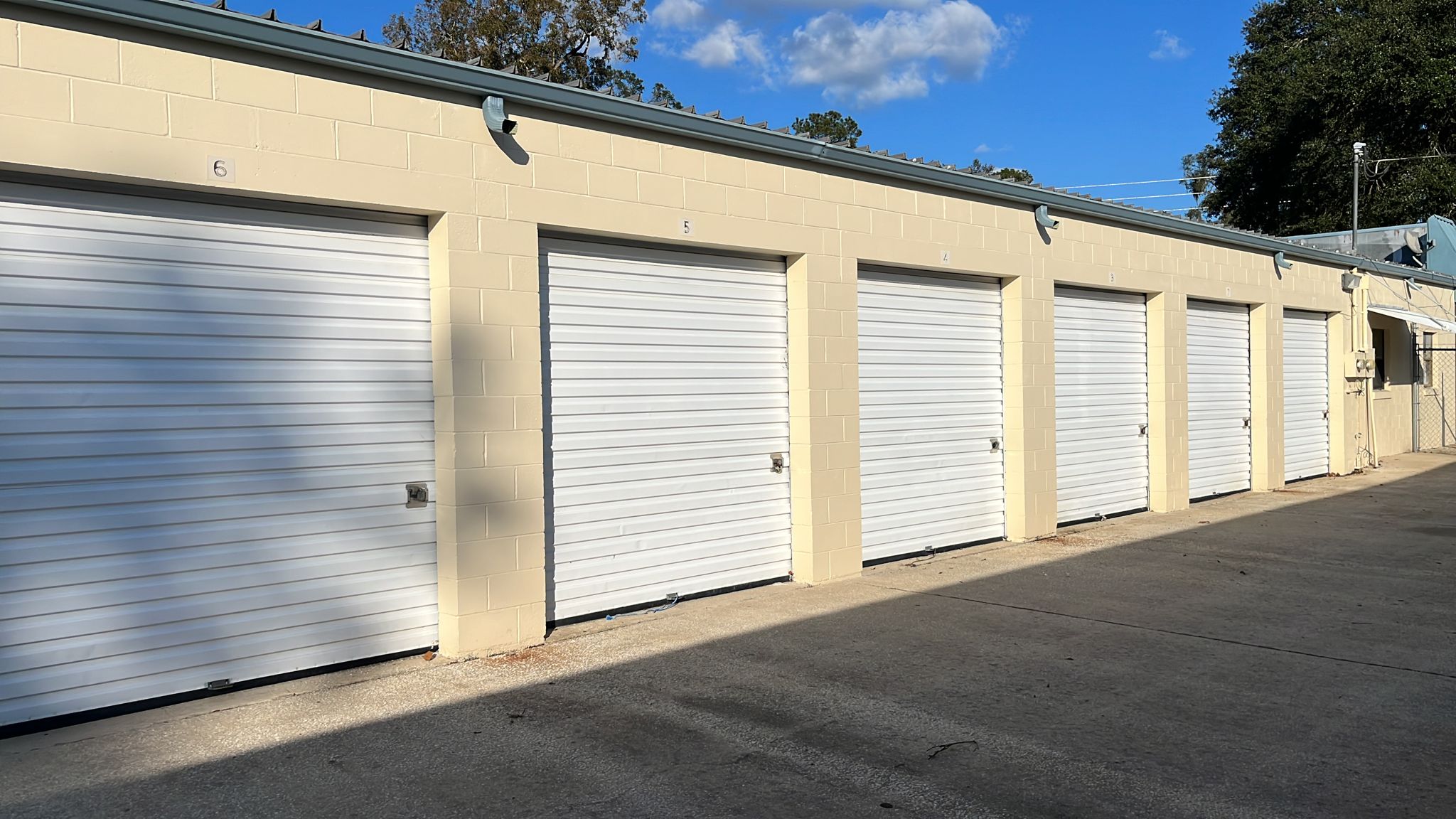 Boats and an enclosed trailer in outdoor parking spaces at Ocala Storage Park