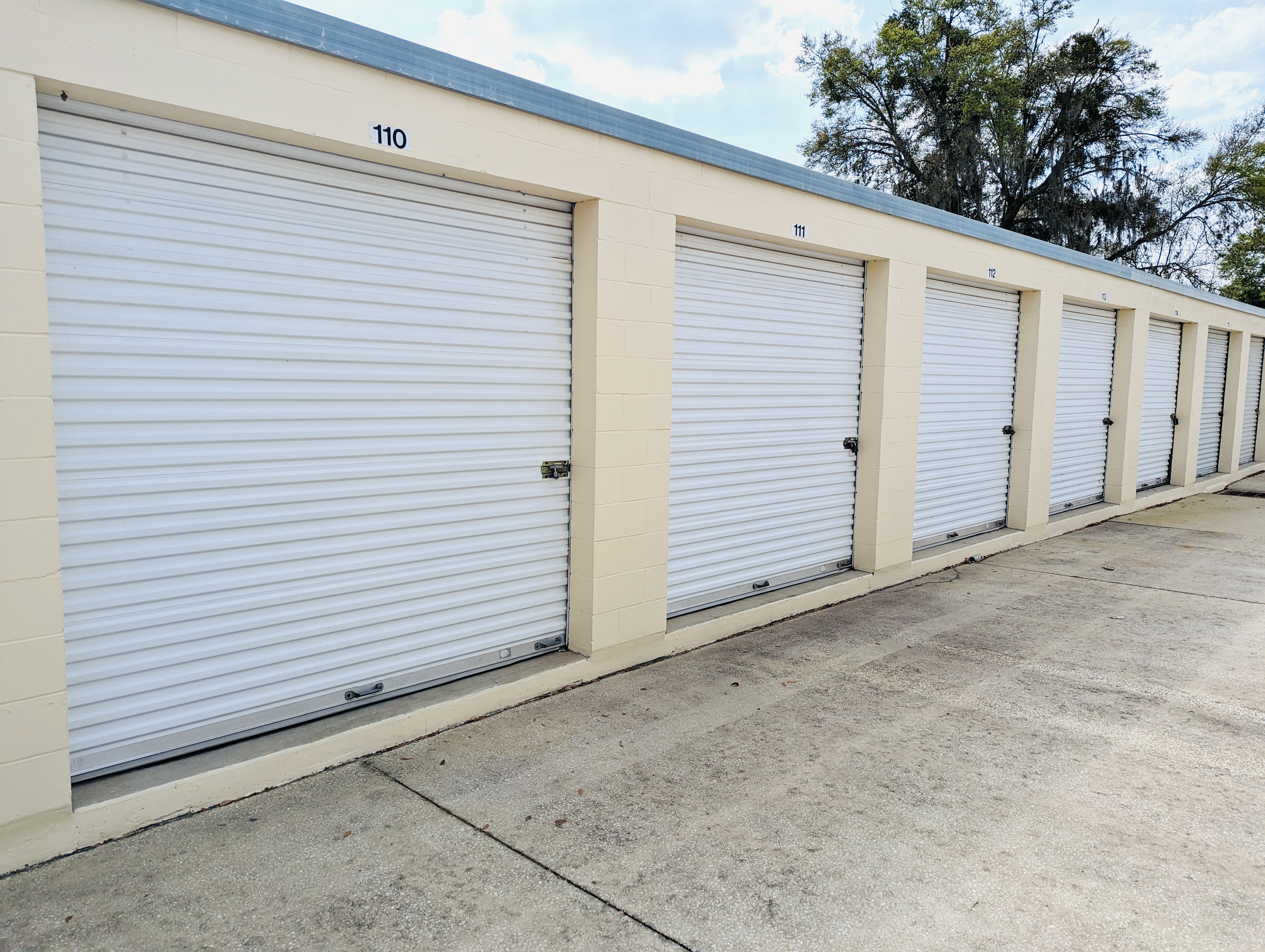 Security cameras mounted above drive-up storage units at Ocala Storage Park