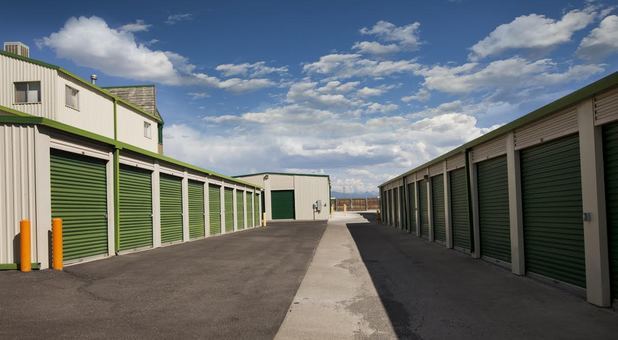 two buildings of self storage units with drive up access with a wide driving lane between them