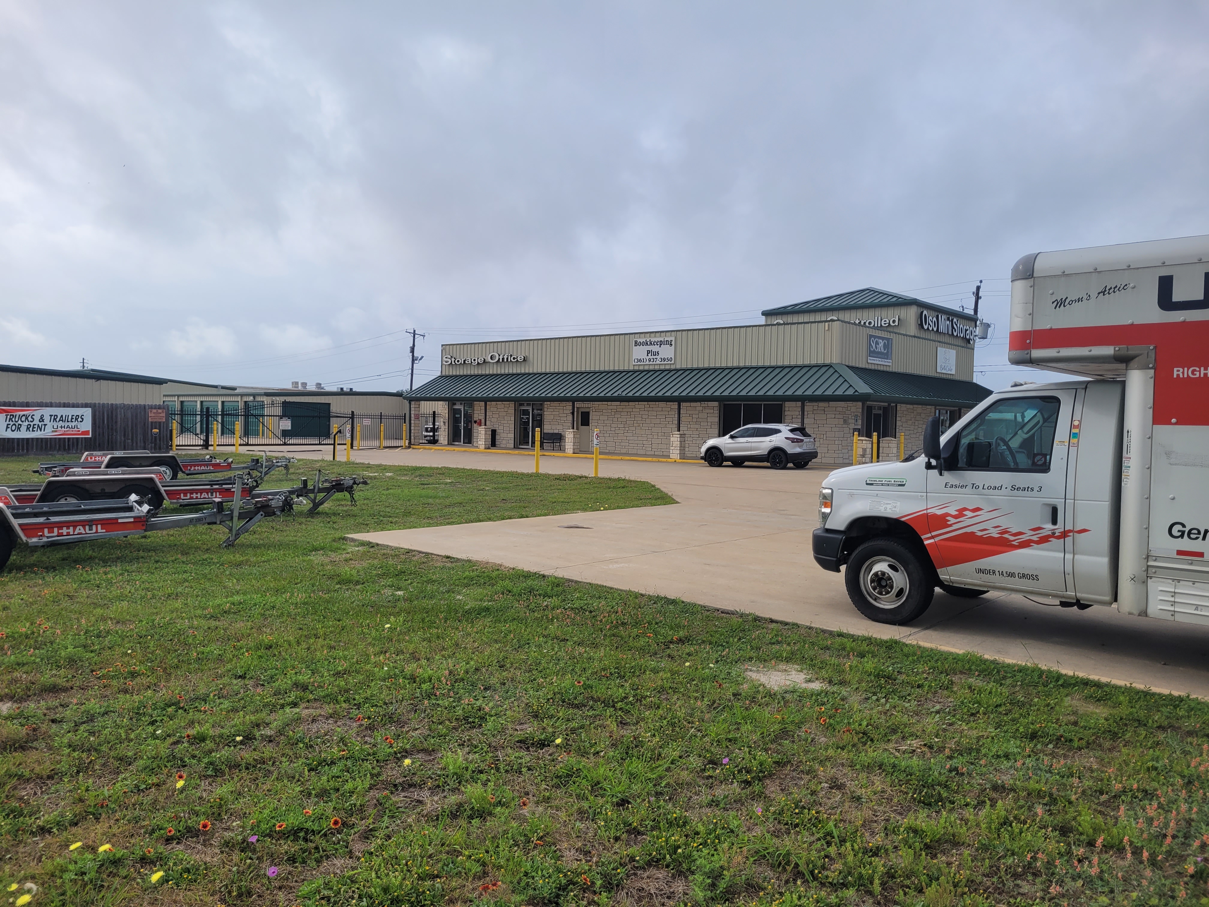 Front view of Oso Mini Storage facility in Flour Bluff, Corpus Christi, TX, featuring U-Haul truck rentals, trailers, and secure storage office—ideal for holiday décor and seasonal gear storage.