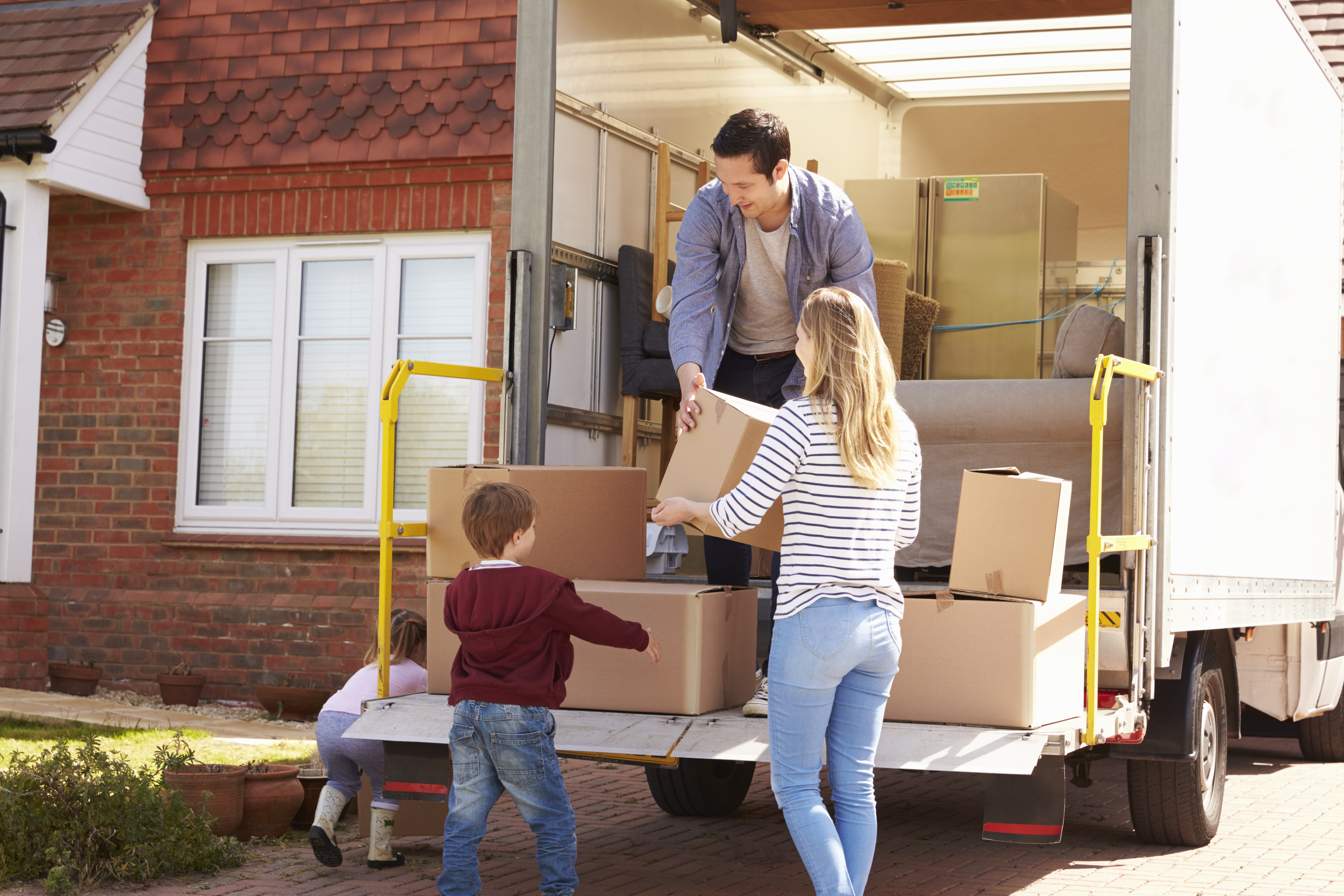 Family carrying moving boxes into a new home after relocating from Uhland to Lockhart TX