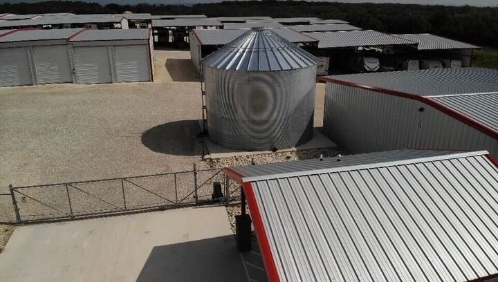 Secure RV and boat storage facility in Boerne, Texas featuring covered units, gated entry, and metal grain silo for added site functionality