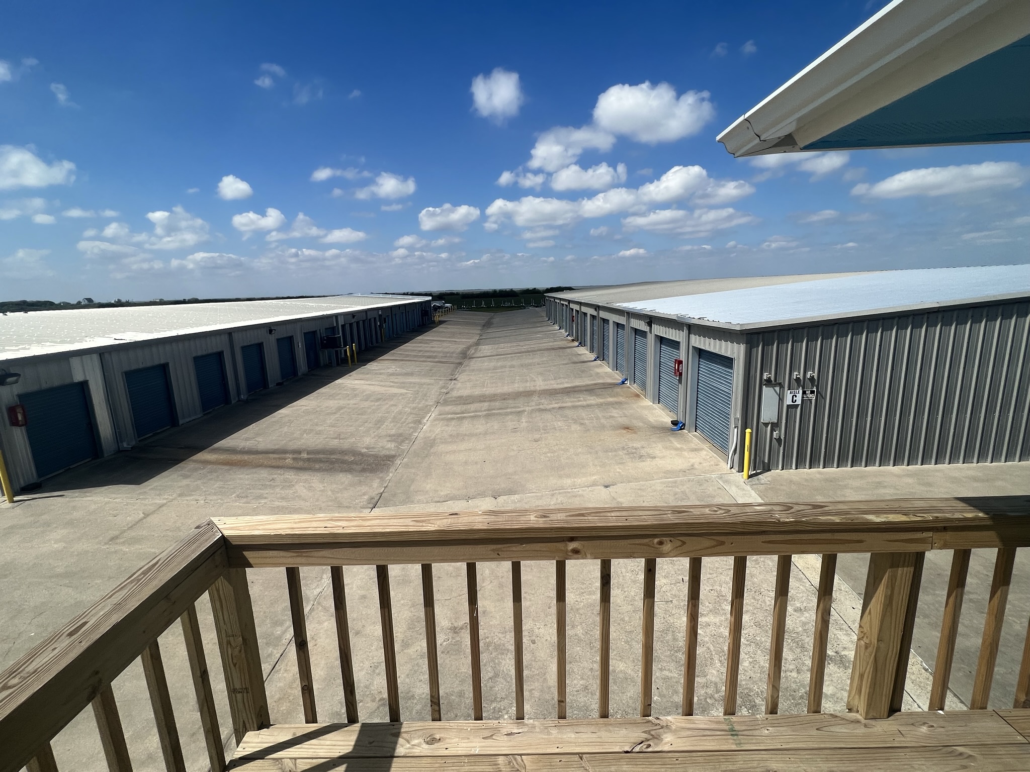 Drive-up storage units at Bayside Storage Galveston near Termini-San Luis Pass Rd Secure self-storage units with drive-up access at Bayside Storage in Galveston, TX, featuring wide paved lanes and metal buildings