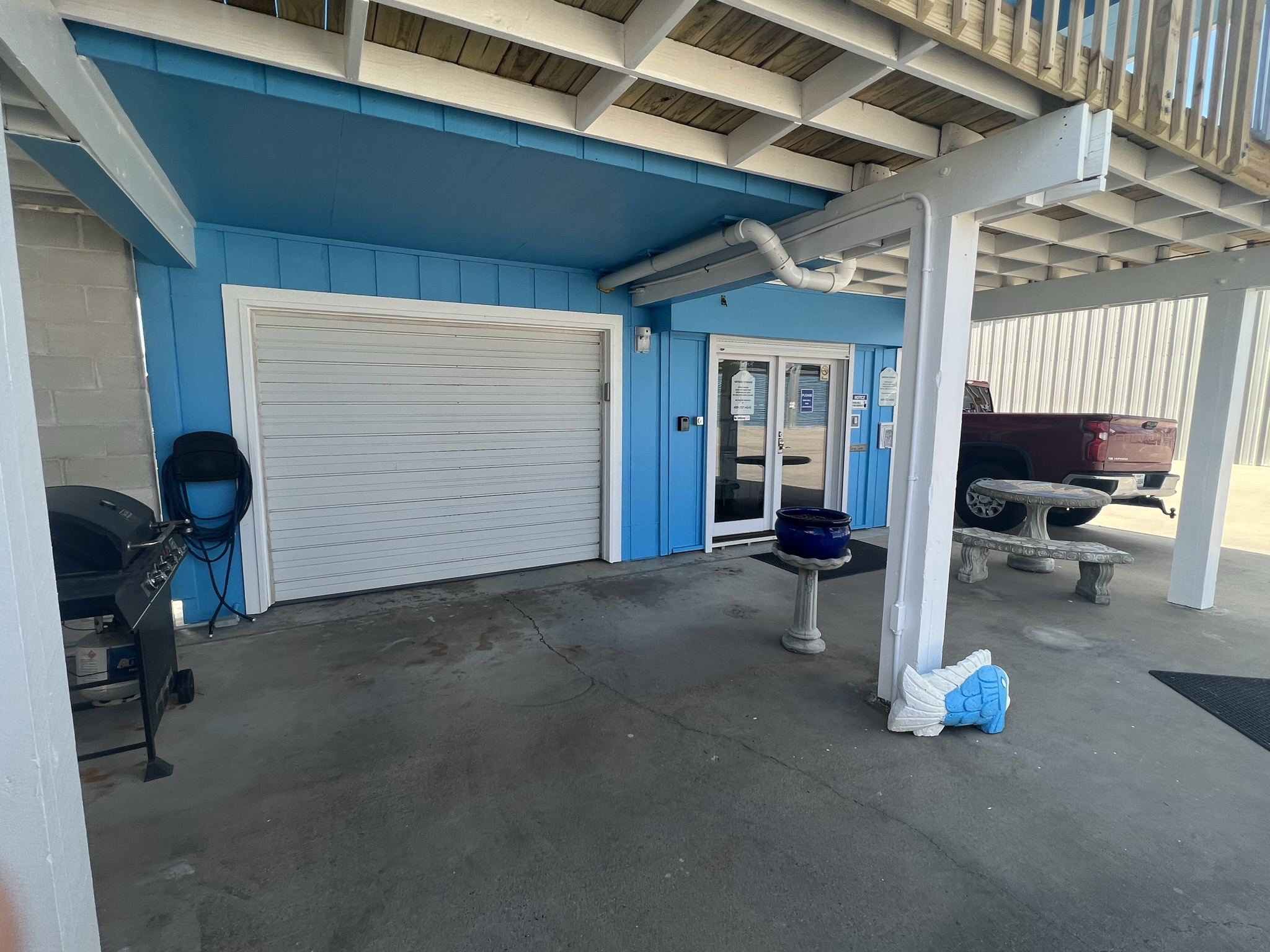 Bayside Storage office near Jamaica Beach with clean entryway, secure access door, and outdoor seating under elevated building