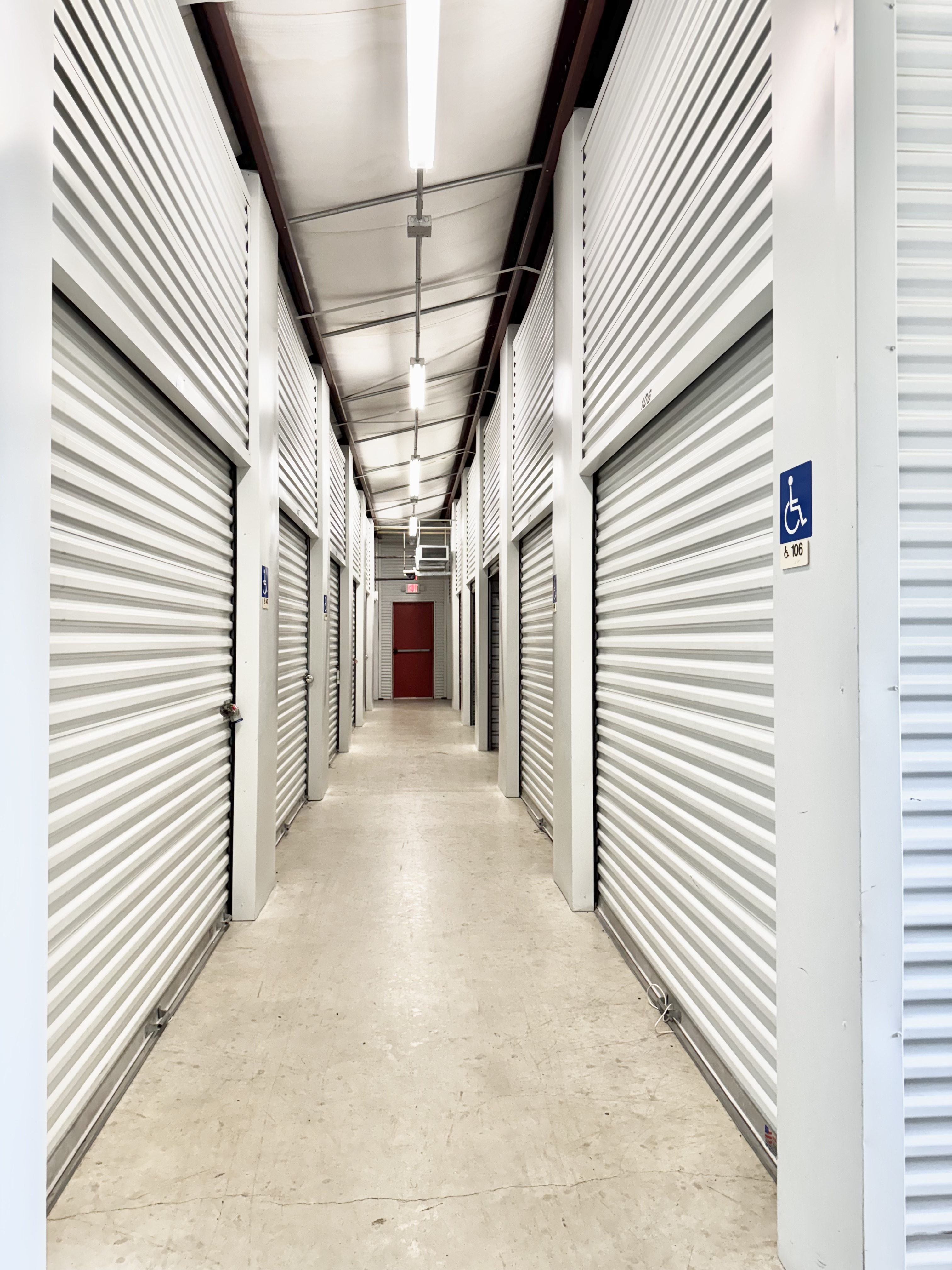 Interior hallway of climate-controlled storage units with ADA-accessible roll-up doors at LockSmart Climate Storage near San Marcos and Lockhart, TX