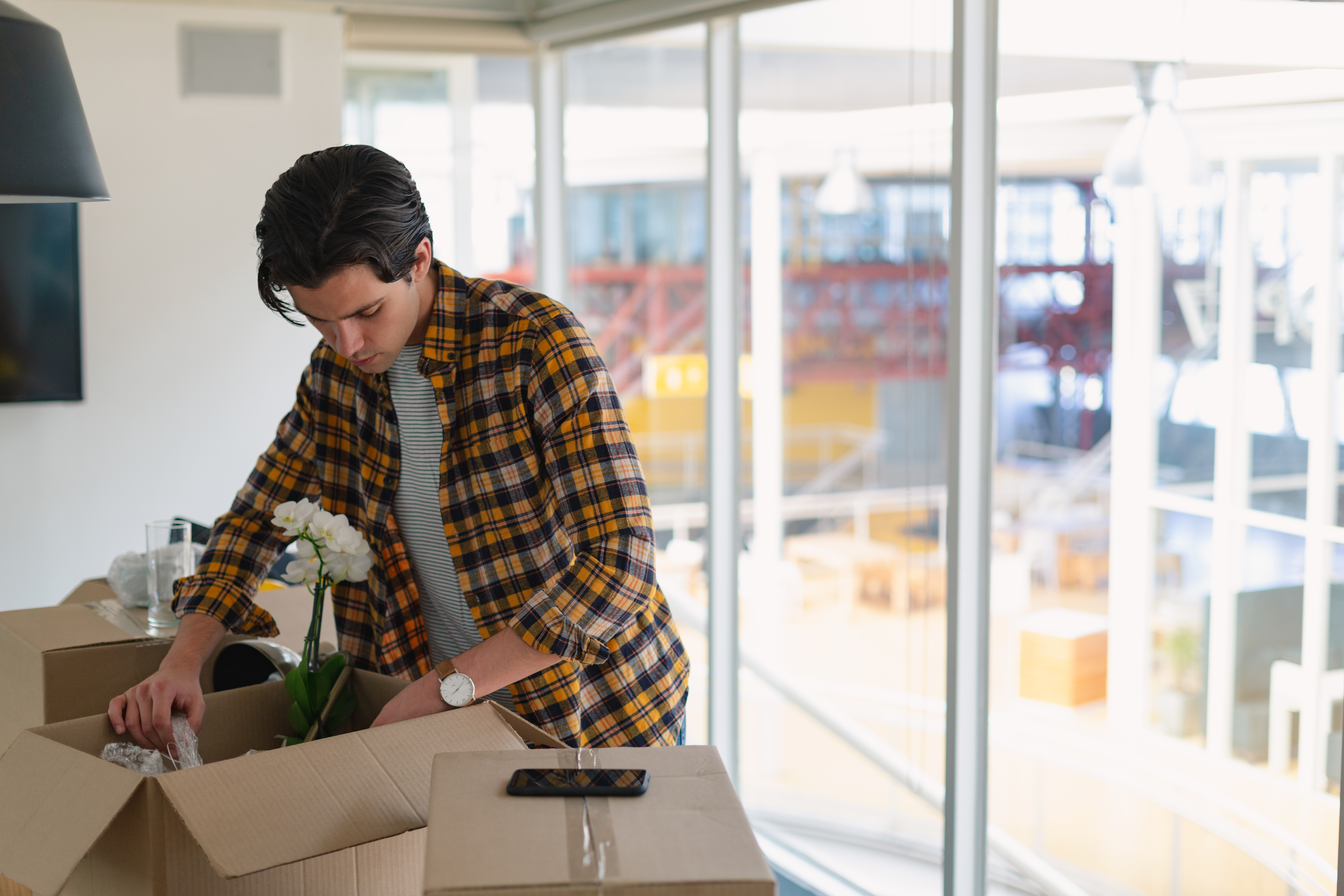 College student packing labeled boxes for summer storage near Royse City, Texas