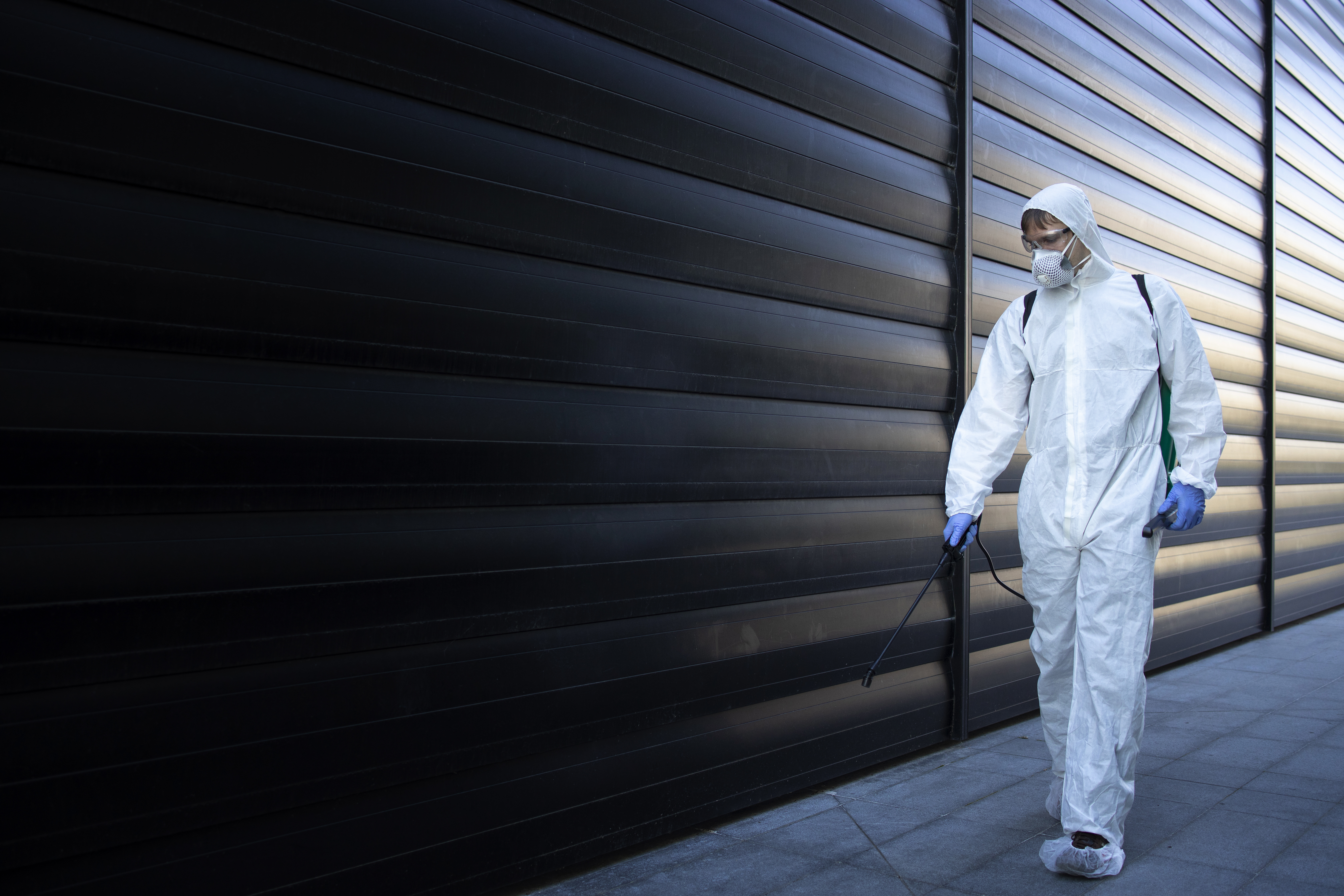 Pest control technician treating a clean self-storage facility to protect stored belongings from damage