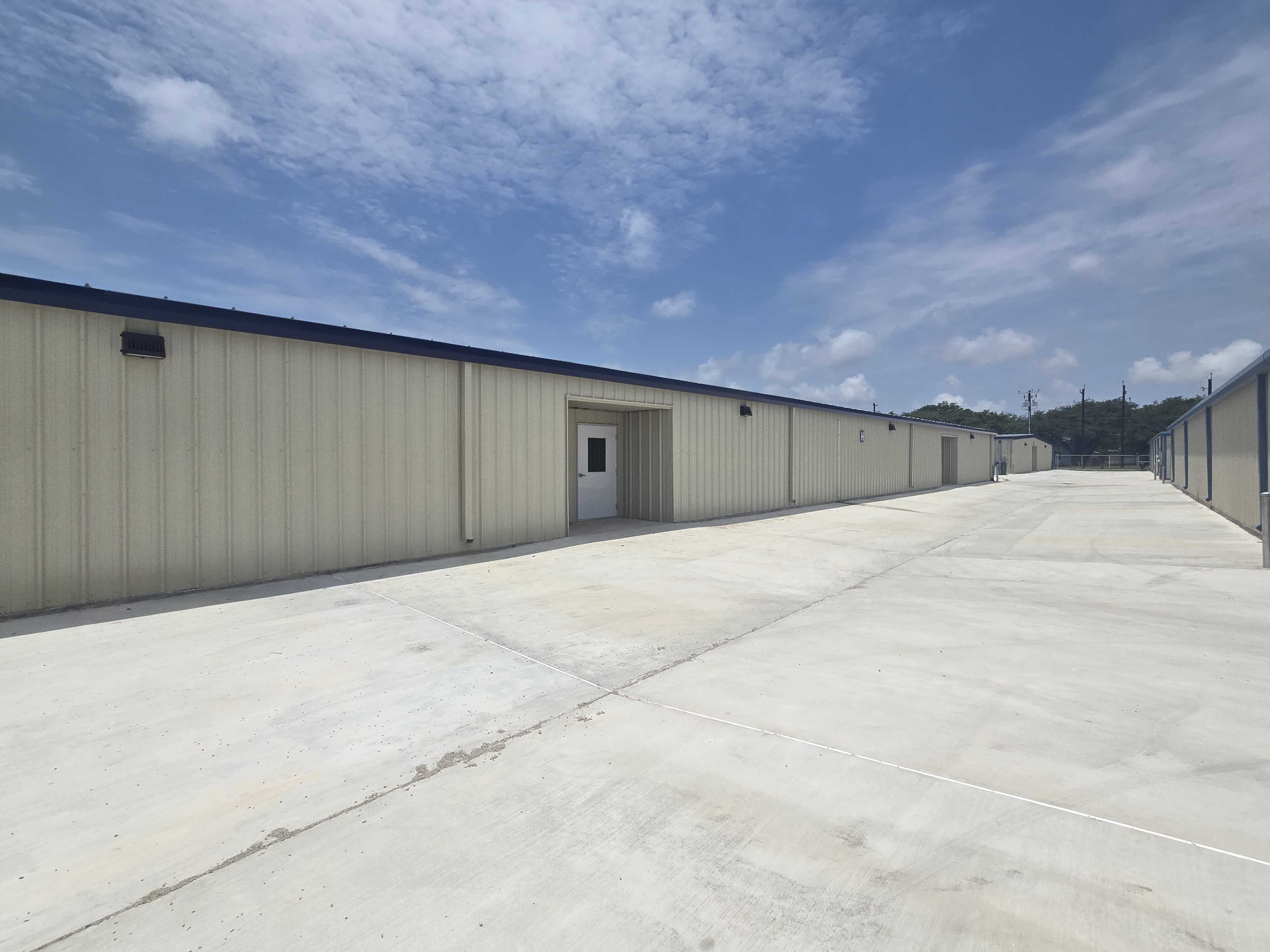 Drive-up storage units with wide concrete access lanes in Rockport, TX, offering convenient and secure self-storage solutions for residents.