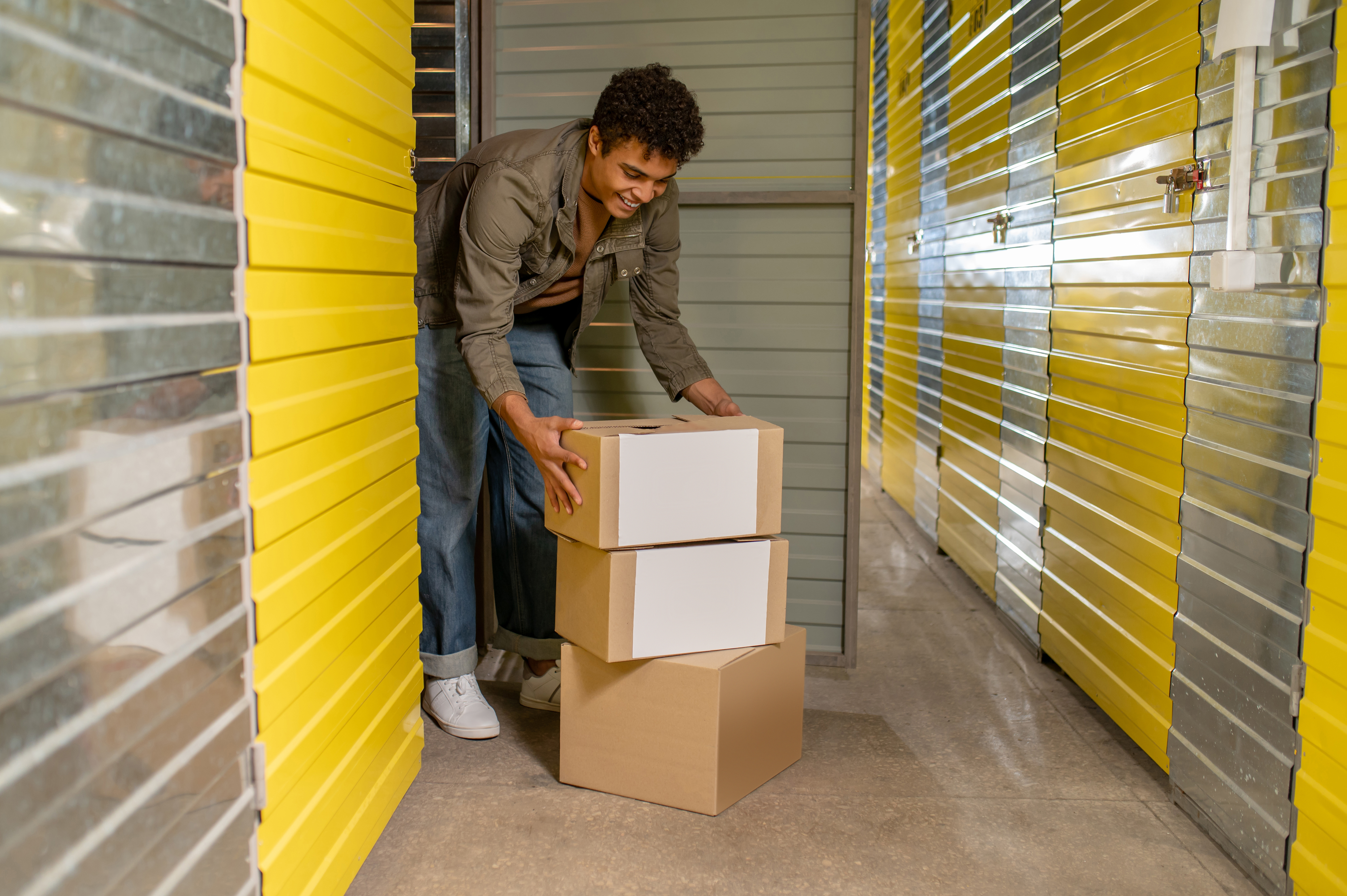 College student loading dorm boxes into affordable semester break storage unit near Spicewood, Texas
