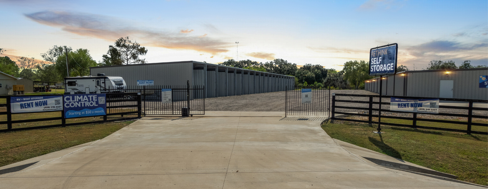 Entrance to Rethink Self Storage in Hamshire, TX, featuring climate-controlled storage units and secure gated access for RV and boat storage. Signs highlight affordable rates starting at $50 per month and a welcoming, spacious layout.