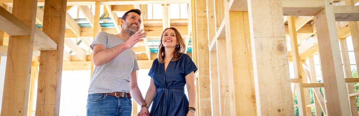 couple excitedly looking at home build in progress