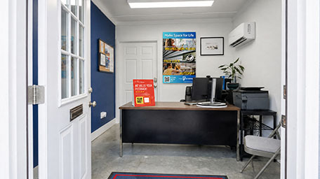 Interior view of Oglethorpe self-storage office with reception desk seen through open door.