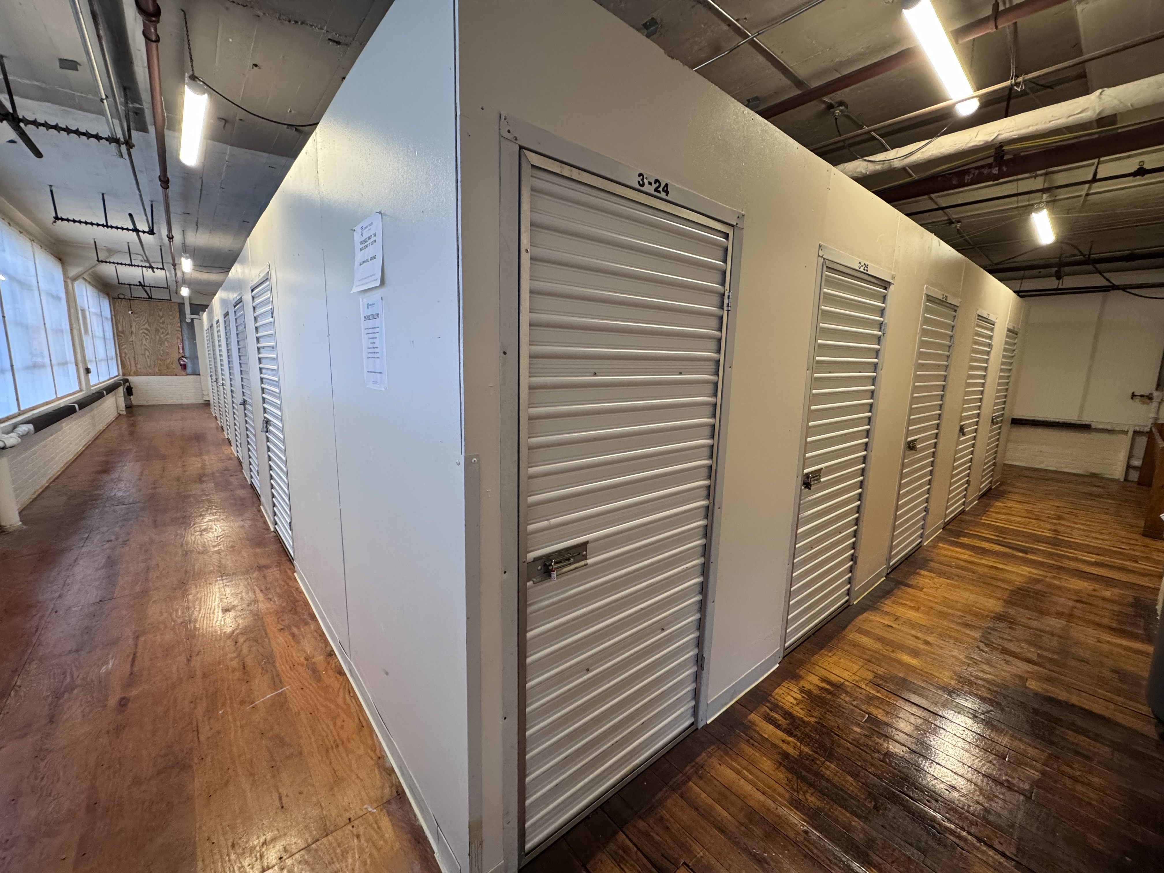 Long hallway view of storage unit doors, well-lit and organized for easy access and navigation.