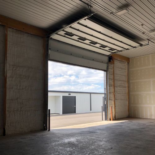 interior of a warehouse with a roll up door rolled all the way up