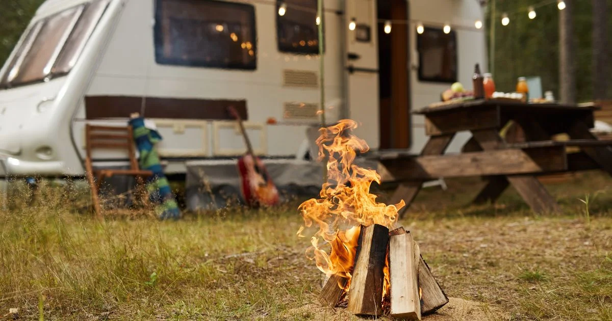 Campfire burning beside RV campsite