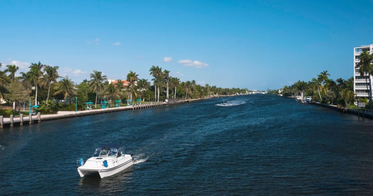 Motorboat traveling along palm-lined Florida canal waterway