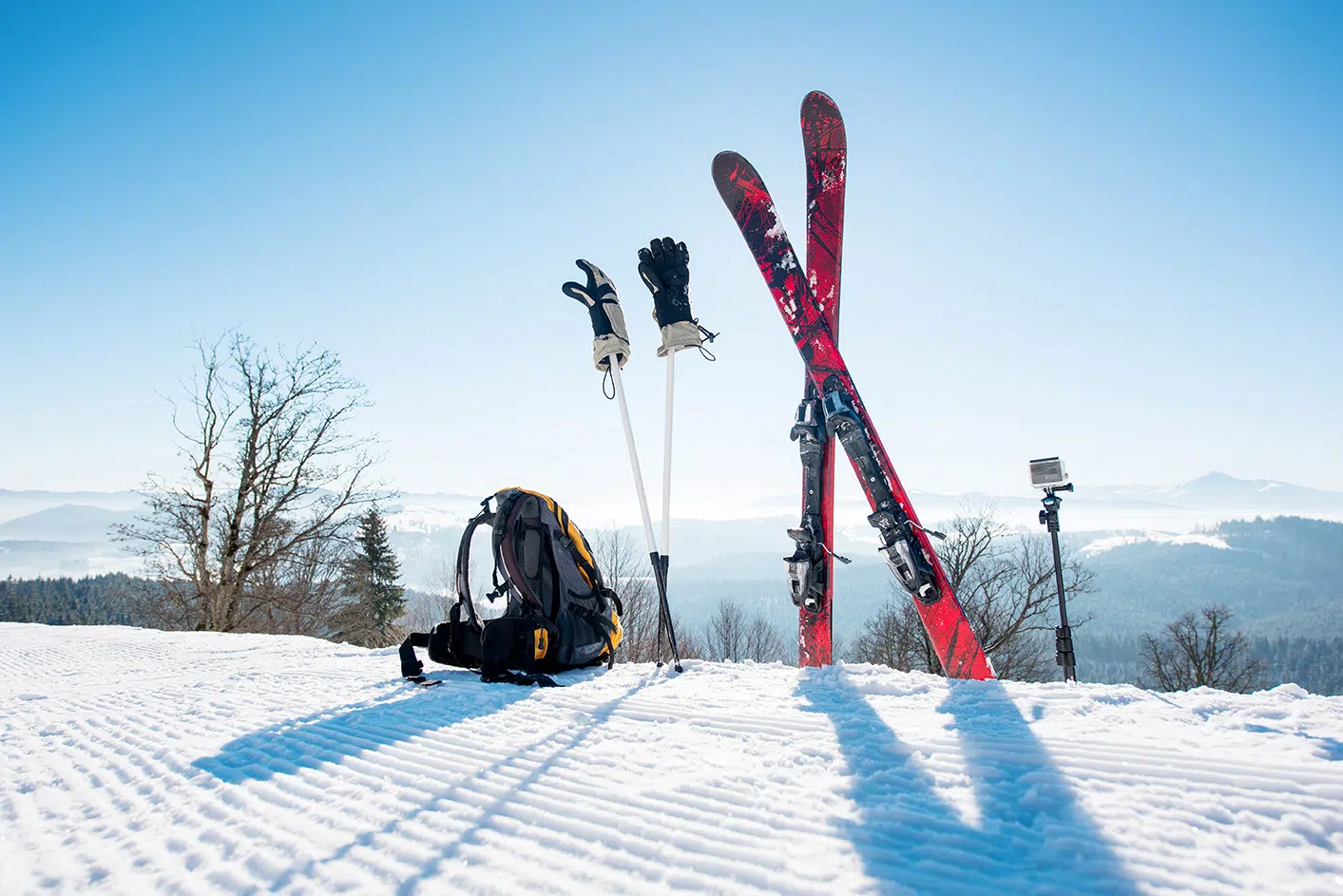 A-Verdi Self Storage for Keeping Your Winter Sports Gear in Shape Skis, poles, gloves, and a backpack resting on a snowy slope with mountain views, representing winter sports gear storage