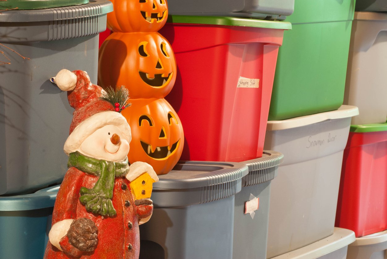 snowman statue, Halloween pumpkins, and storage bins stacked up