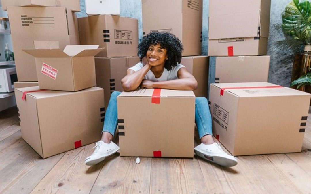 Smiling woman sitting amongst moving boxes