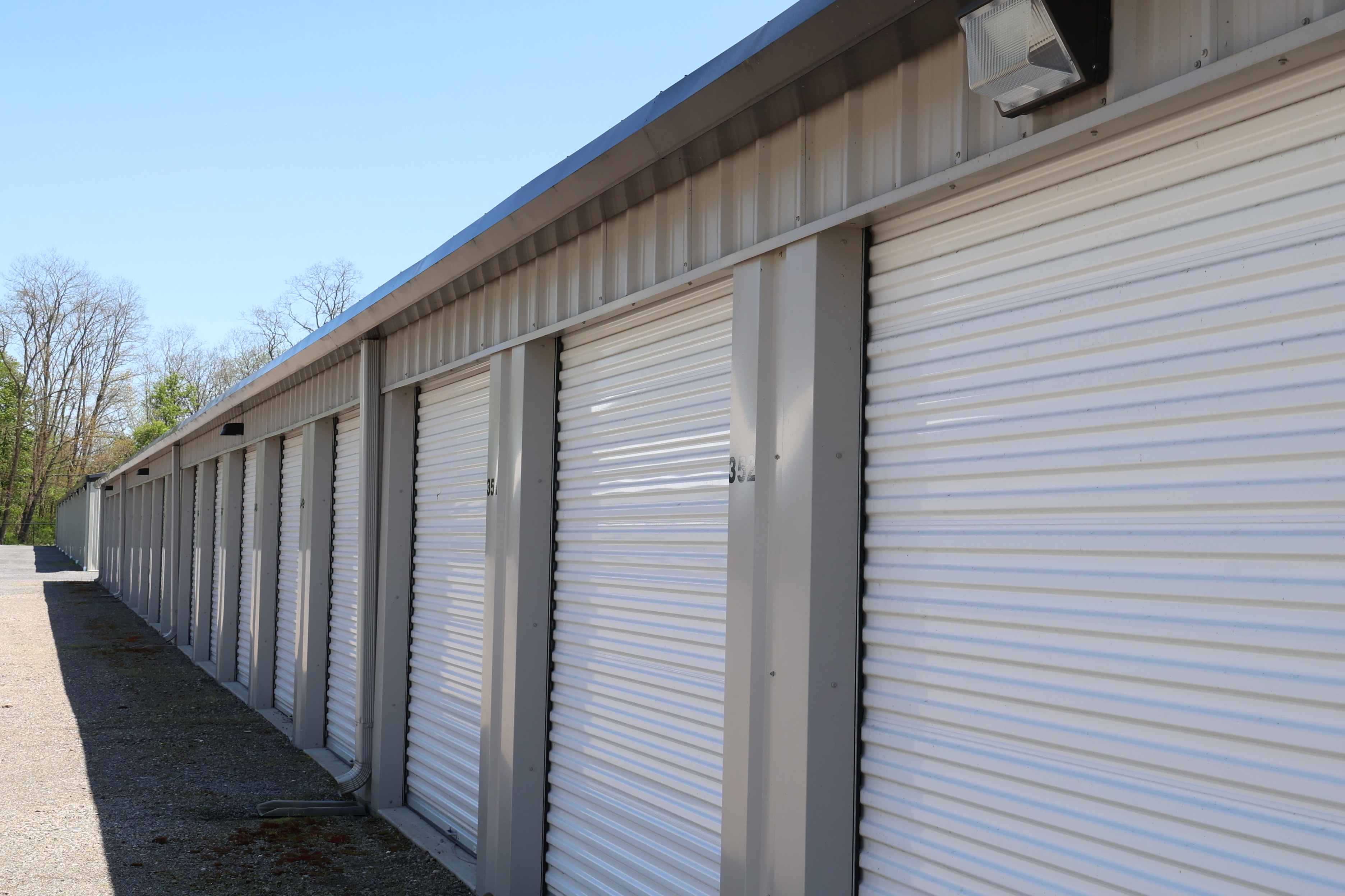 Row of drive-up storage units at A-Verdi Self Storage Waterloo with white roll-up doors and paved access lane