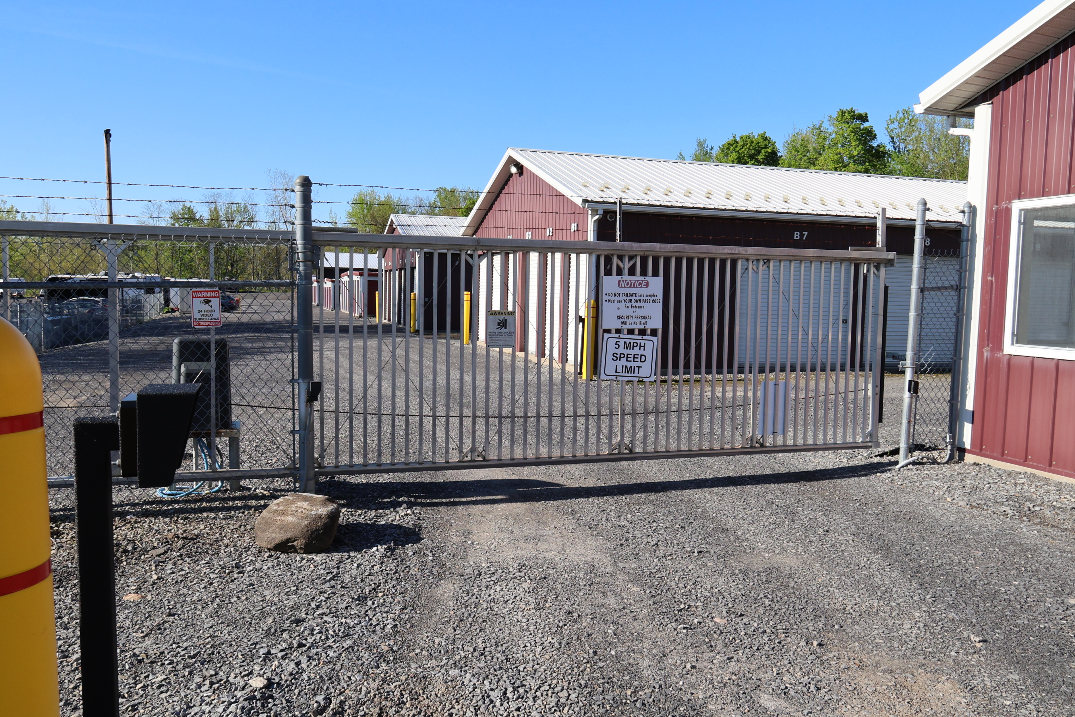 Secure gated entrance at A-Verdi Self Storage Syracuse with controlled access gate, fencing, and on-site signage