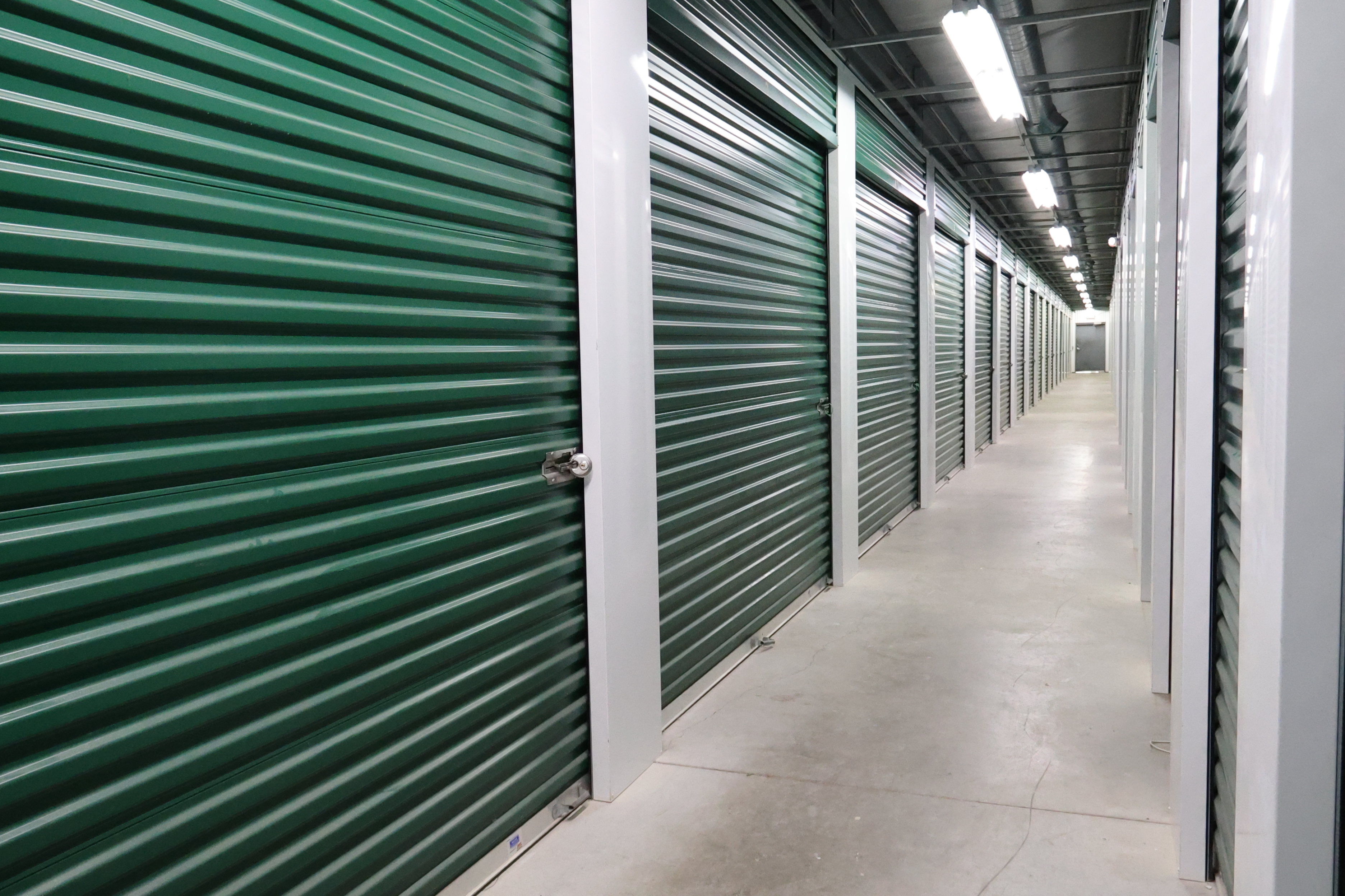 Indoor storage hallway at A-Verdi Self Storage Baldwinsville with clean, well-lit units and secure roll-up doors