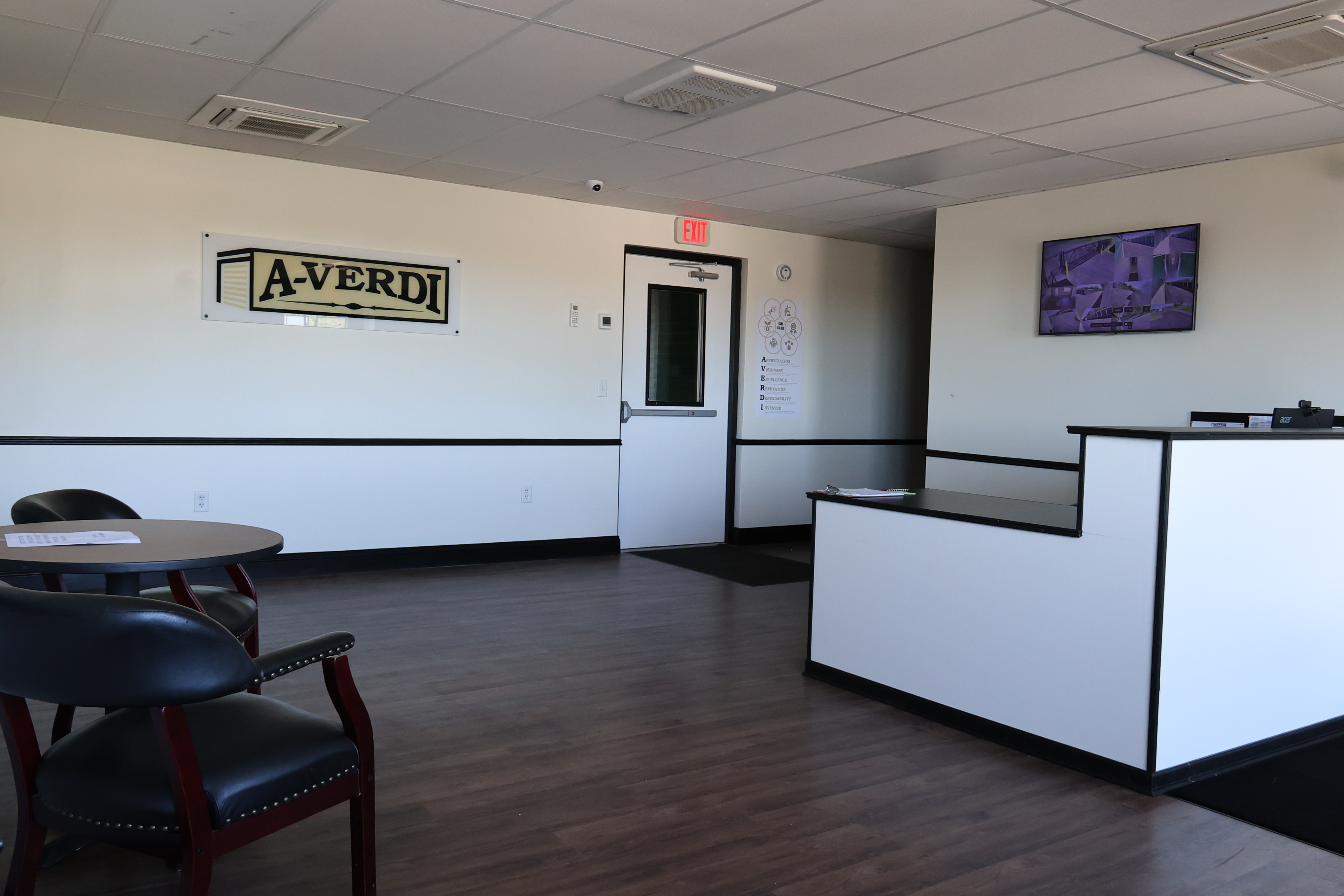Interior of A-Verdi Self Storage Clay office with customer service counter, waiting area, and security monitor display