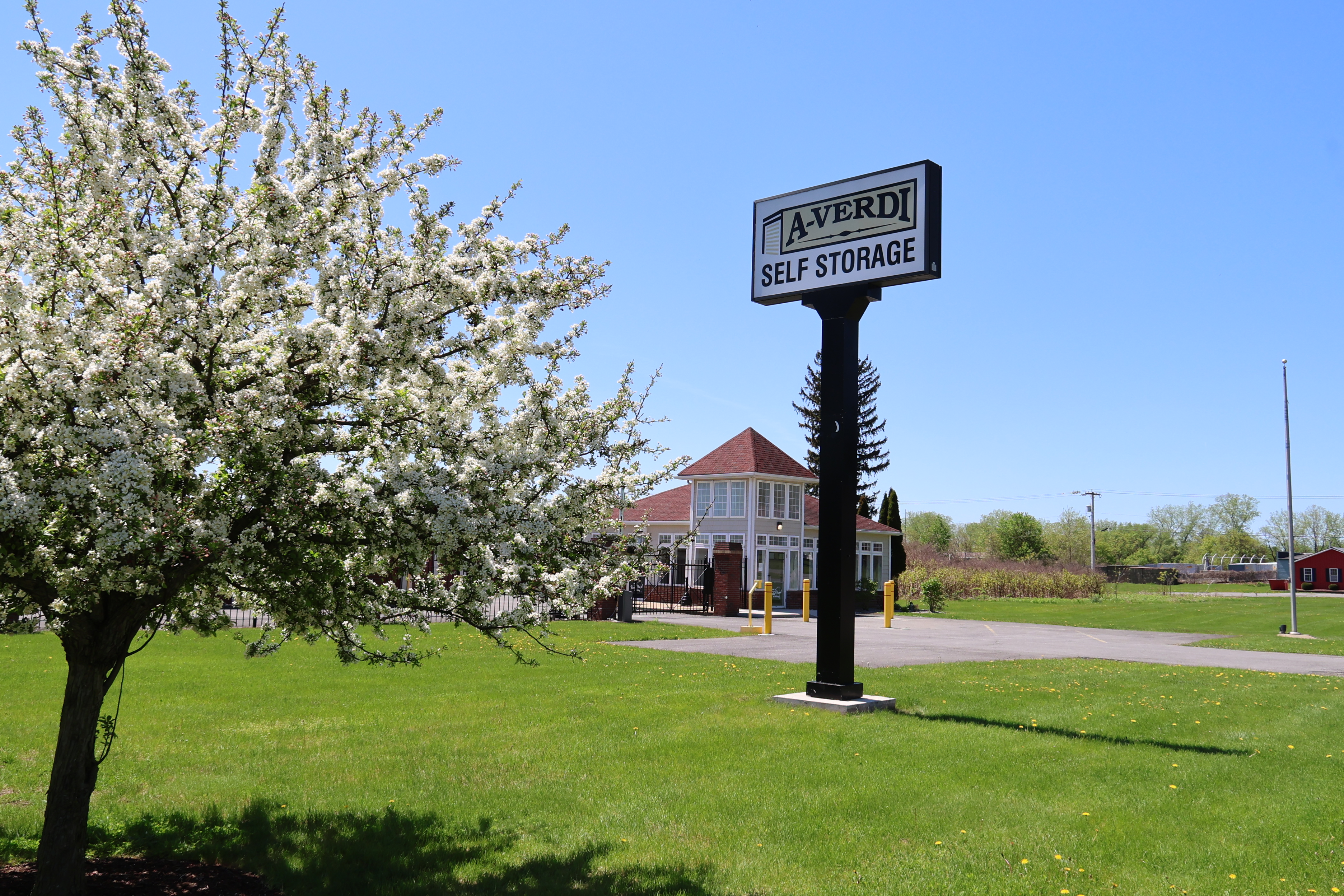 A-Verdi Self Storage Marcy roadside sign with landscaped lawn and office building in the background