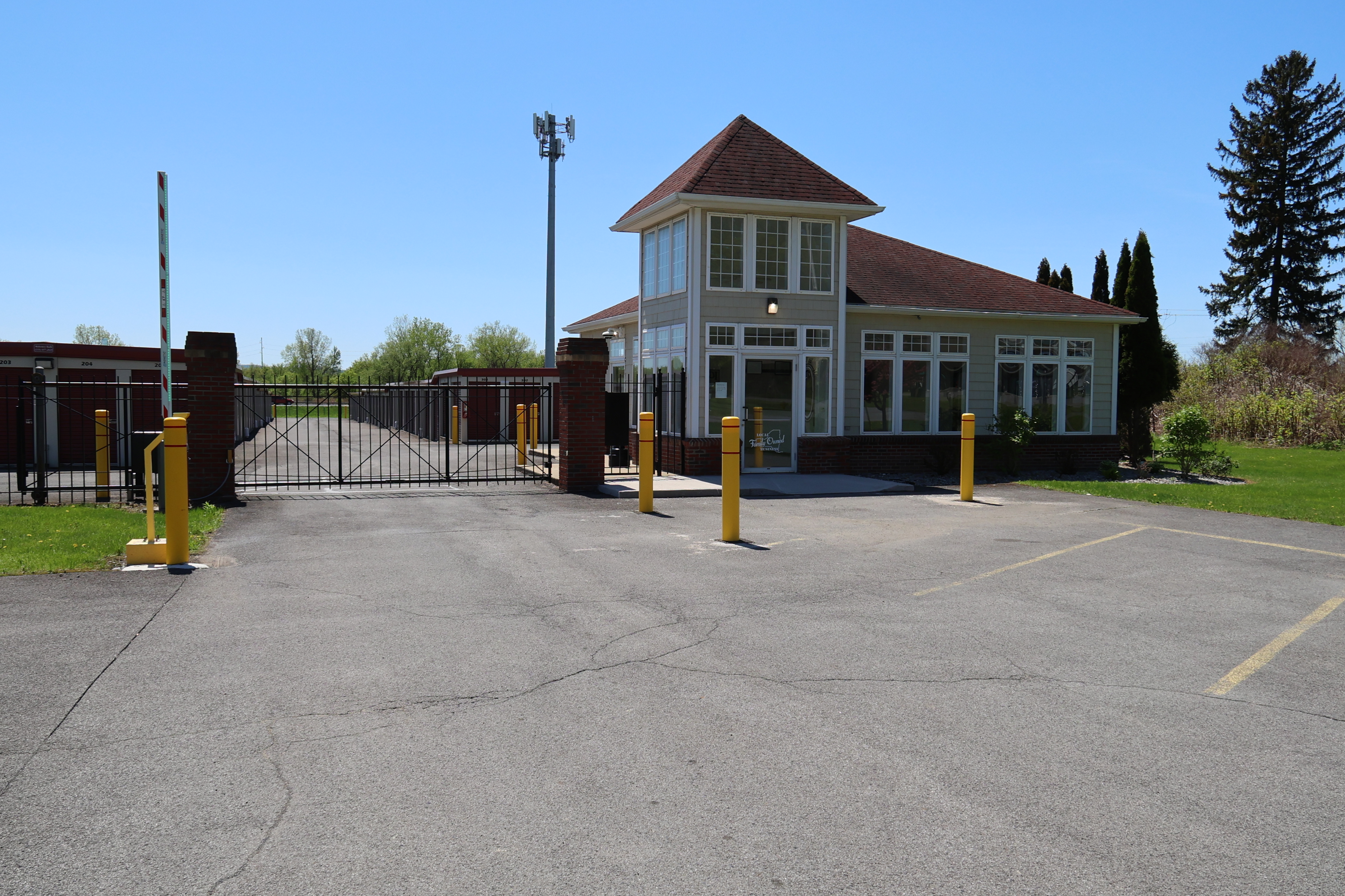 Front office and gated entrance at A-Verdi Self Storage Marcy with controlled access and security bollards