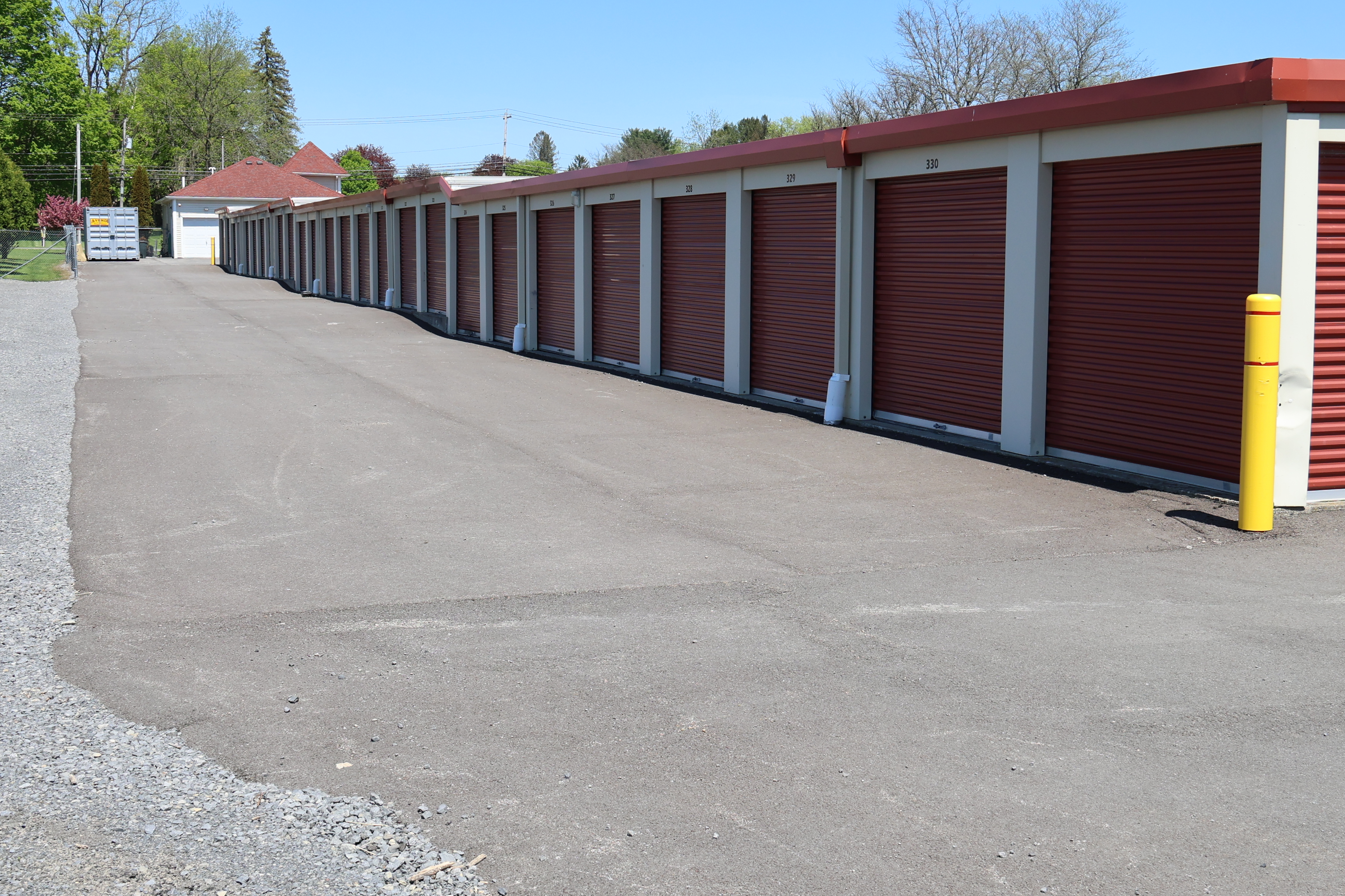 Drive-up storage units at A-Verdi Self Storage Marcy with paved access and red roll-up doors