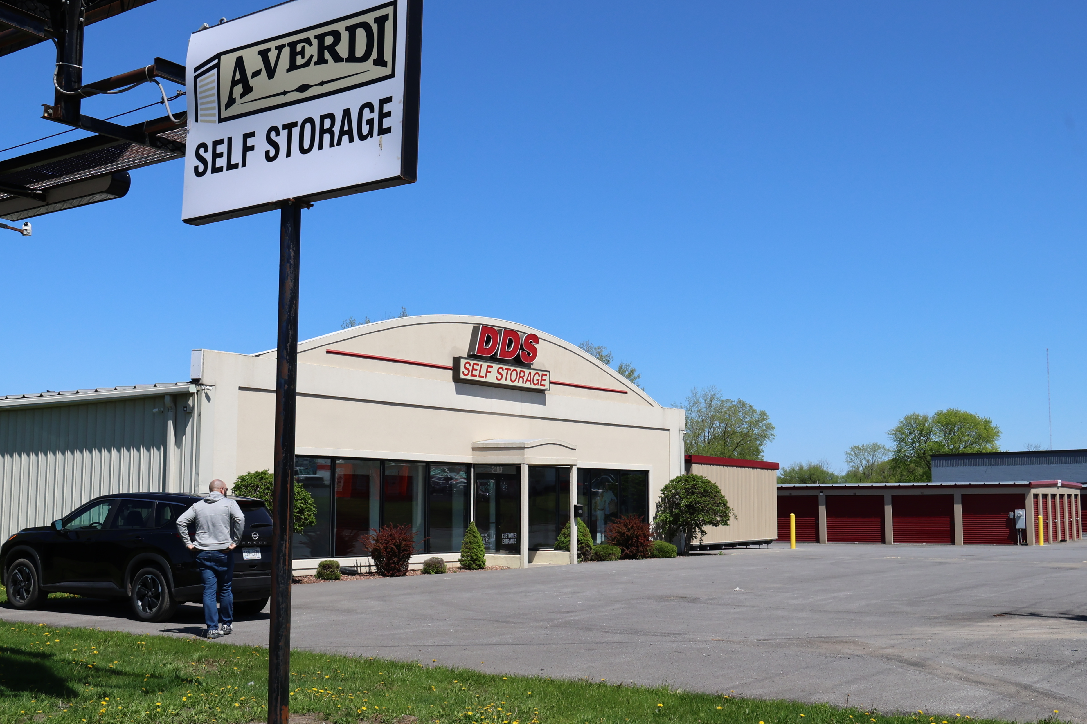 A-Verdi Self Storage Utica roadside sign with office building and drive-up storage units visible on the property