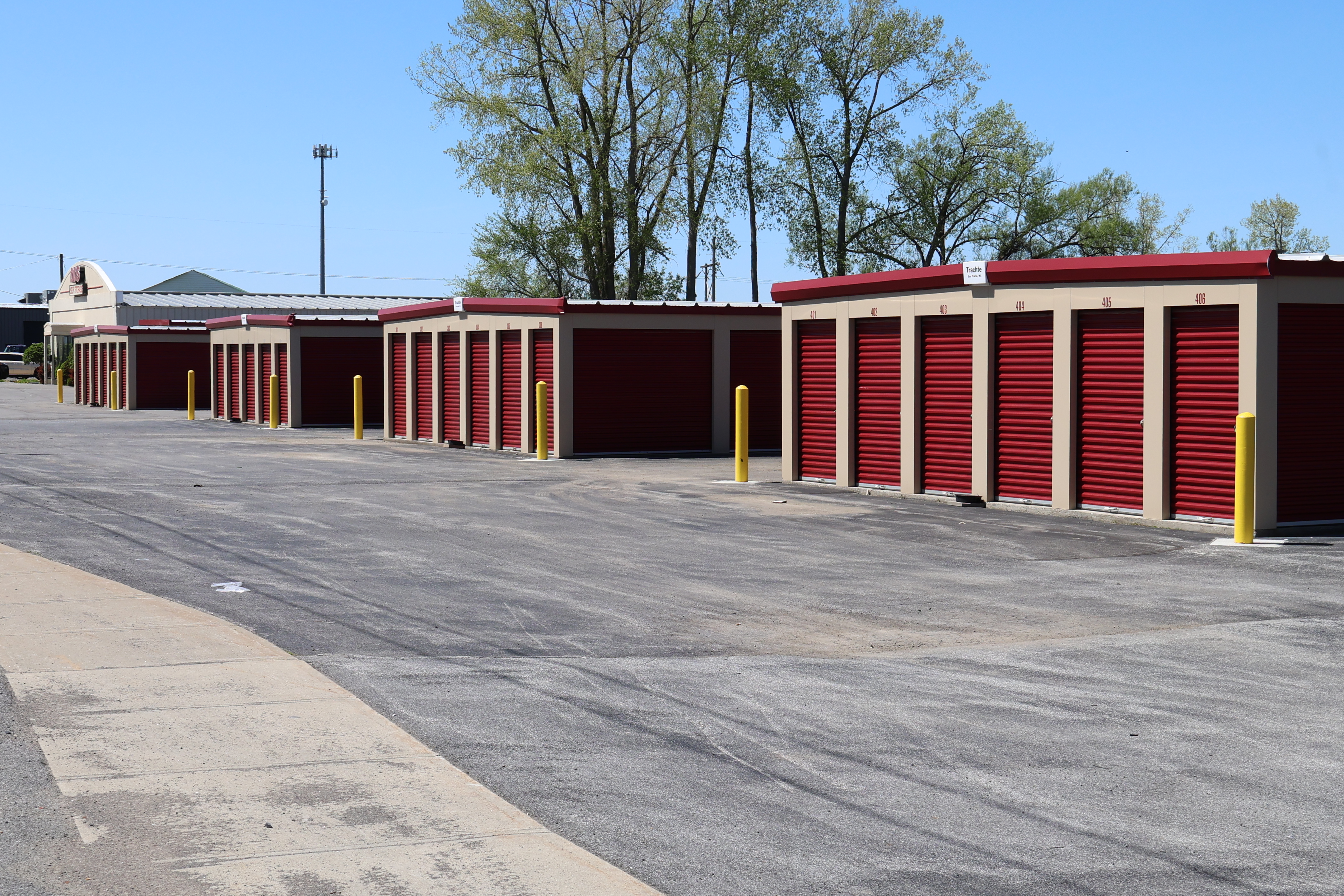 Drive-up storage units at A-Verdi Self Storage Utica with red roll-up doors and wide paved access lanes