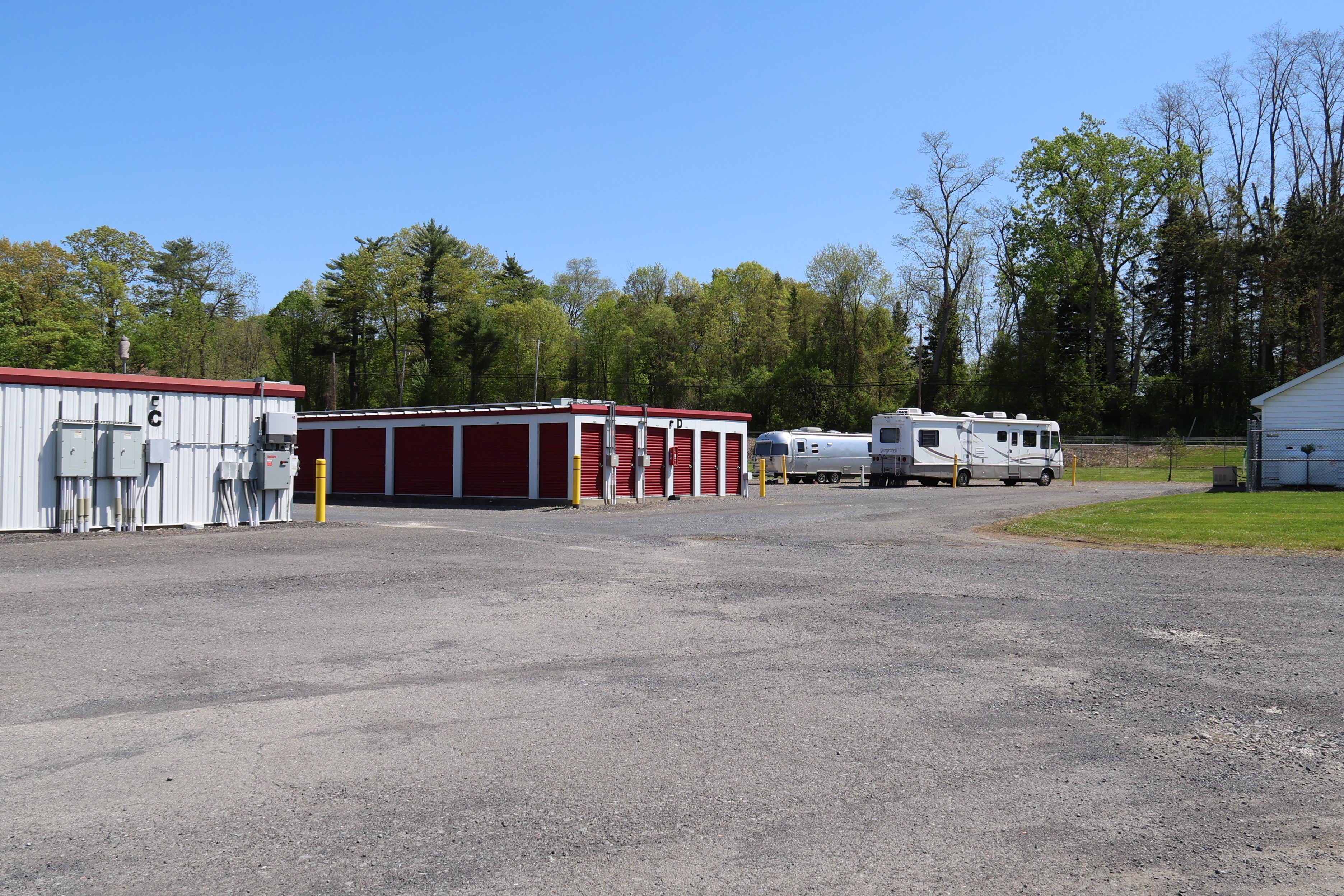 Drive-up storage units at A-Verdi Self Storage Glenmont with wide gravel lanes and roll-up doors