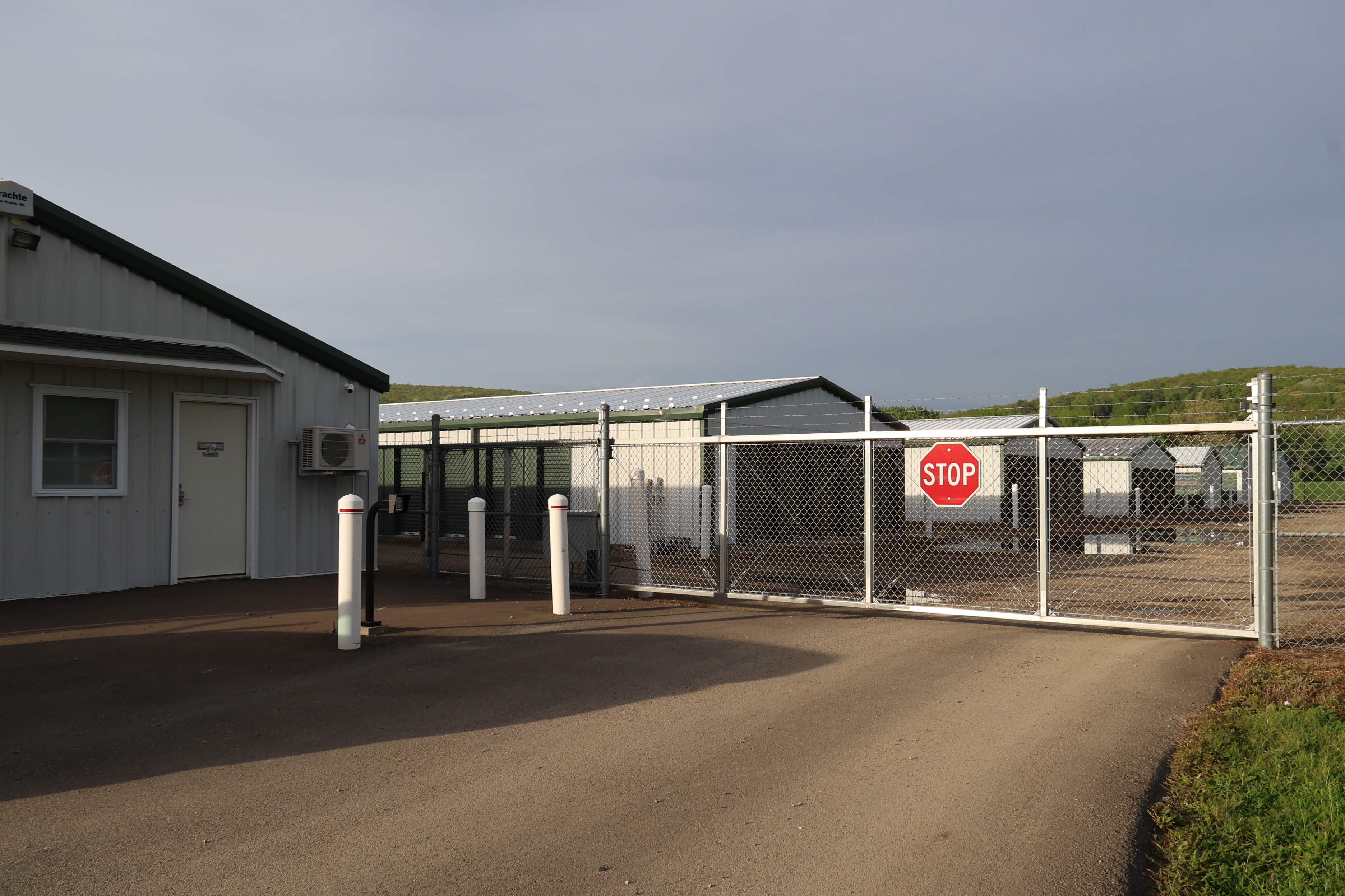 Secure gated entrance at A-Verdi Self Storage Corning with office building and controlled access fencing