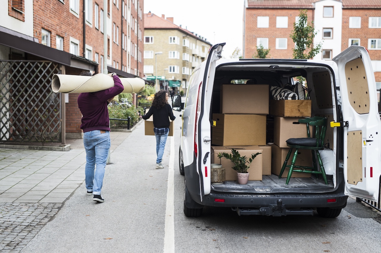 people moving boxes and items from moving van