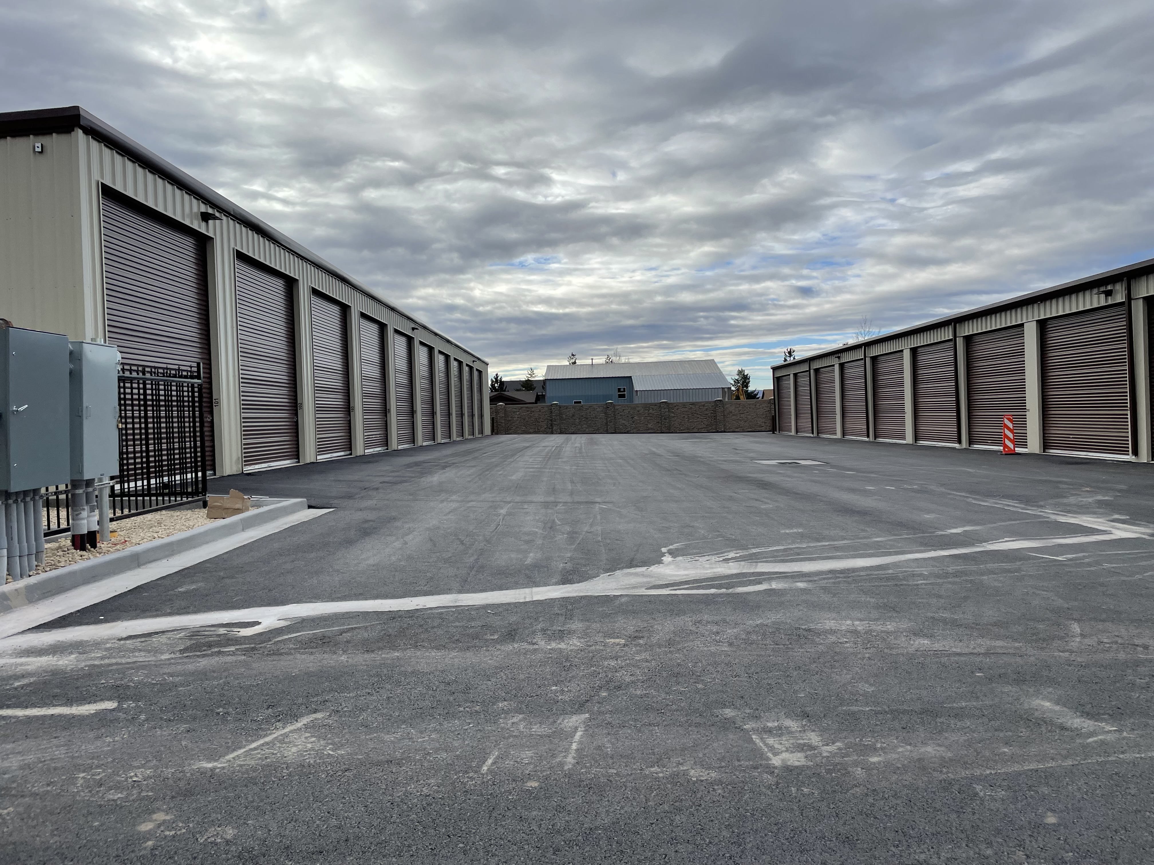 two storage buildings with drive up access units and a wide driving lane