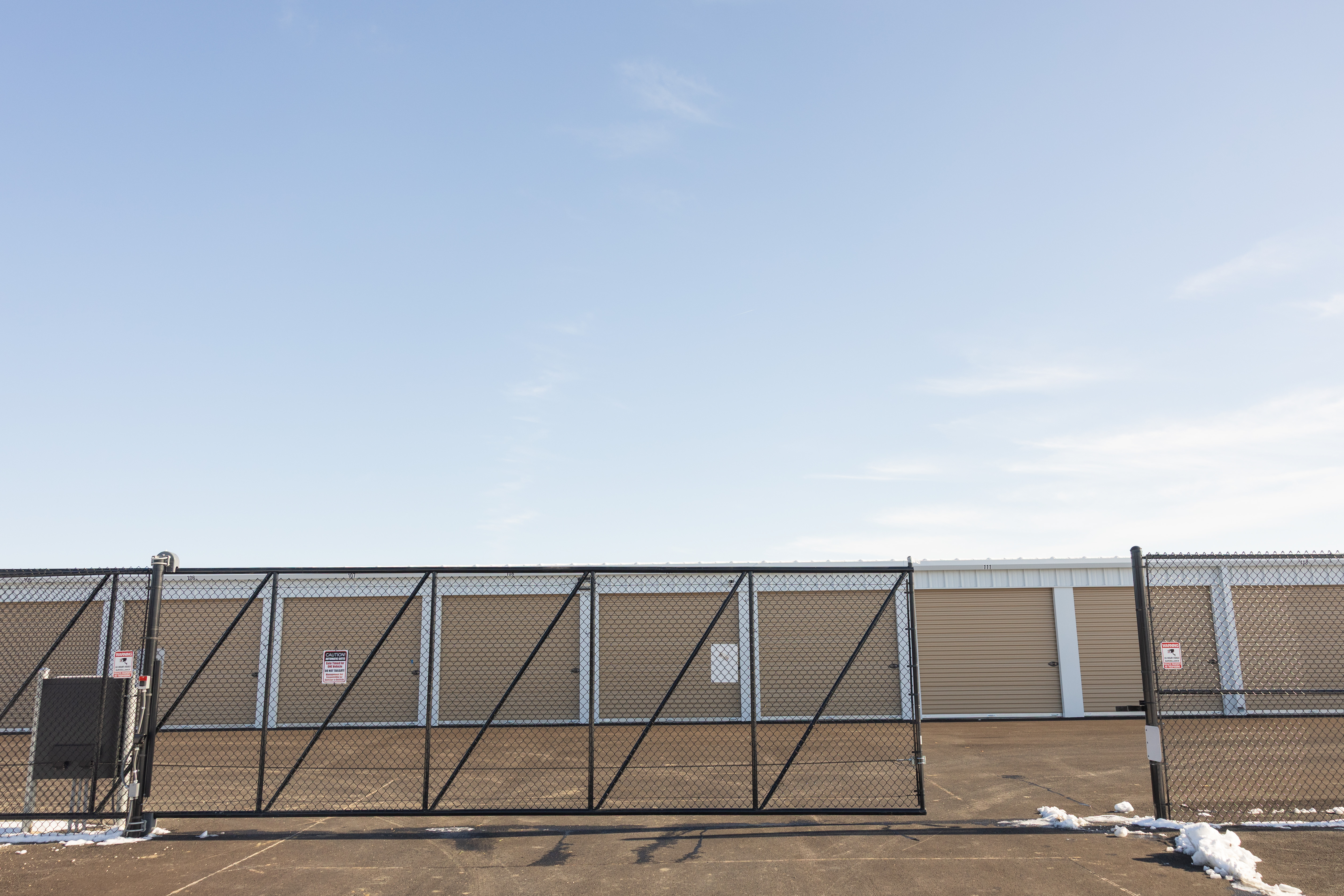 Exterior of Unlimited Storage facility with gated entrance and security fencing