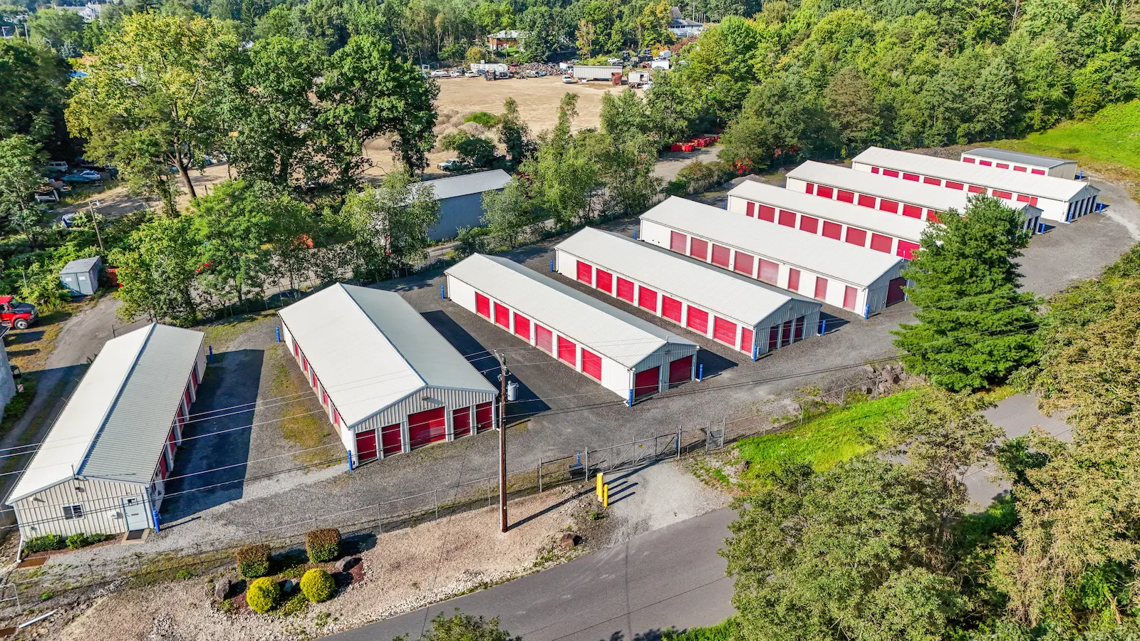 Aerial view of UrbanLock self-storage facility in Scranton showing multiple storage buildings, drive-up access units, secure perimeter fencing, and wooded surroundings