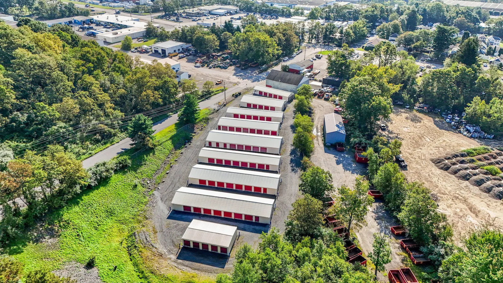 Aerial view of UrbanLock self-storage facility in Scranton showing full campus layout with multiple storage buildings, organized drive-up rows, wooded perimeter, and surrounding industrial area