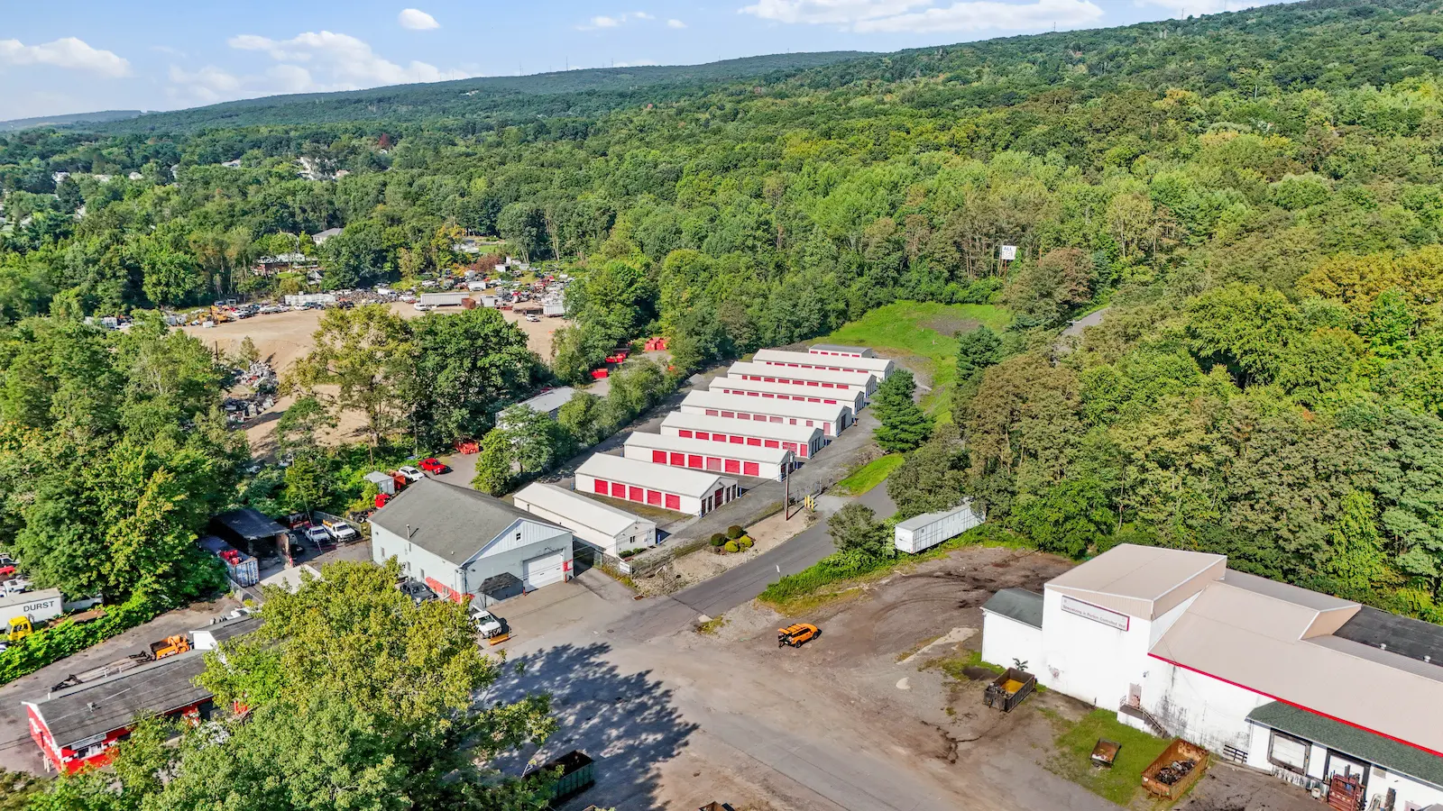 Aerial view of UrbanLock self-storage facility in Scranton with storage buildings nestled in wooded hillside setting, showing surrounding properties and landscape